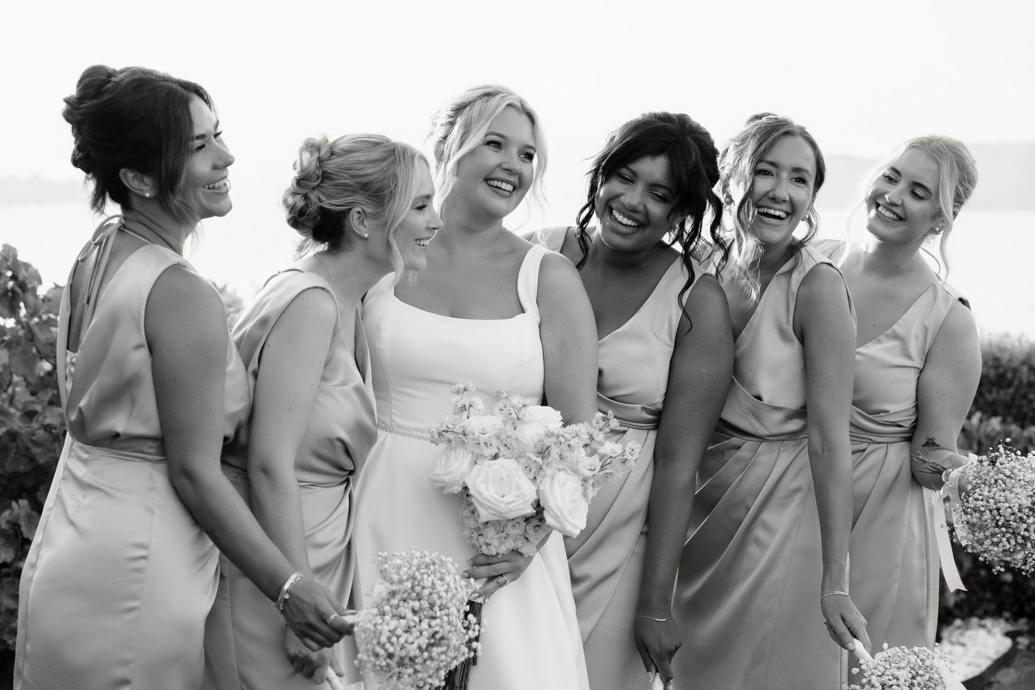 A series of wedding party photos showing bridesmaids in light colored dresses laughing and embracing outdoors.
