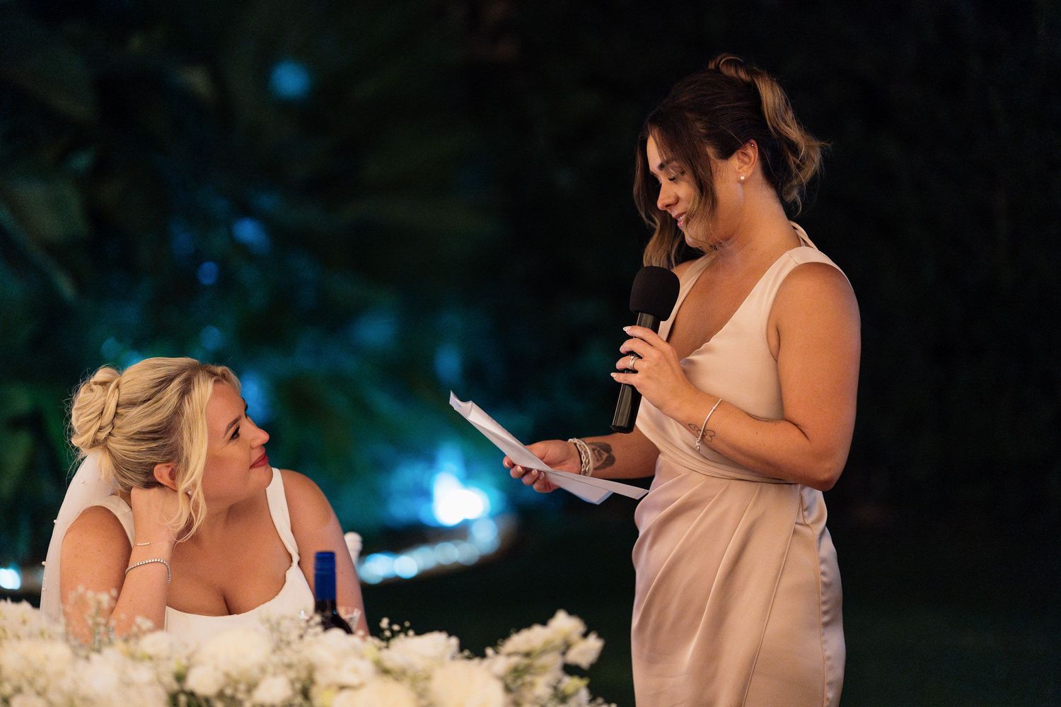 Wedding guests light sparklers during an evening outdoor reception celebration creating a magical nighttime atmosphere.