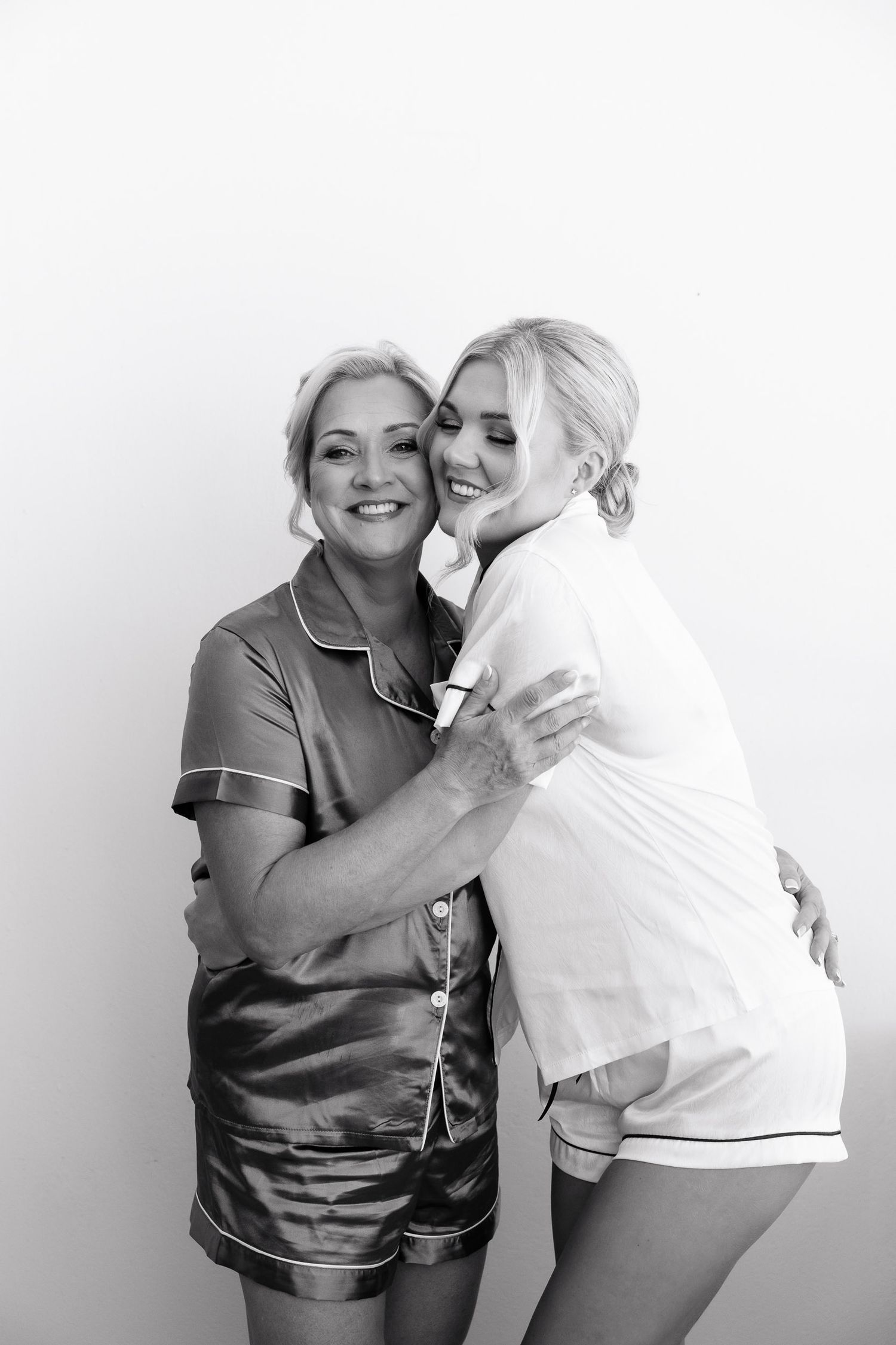 A series of four candid photos showing two people in casual attire embracing and laughing together against a white background.