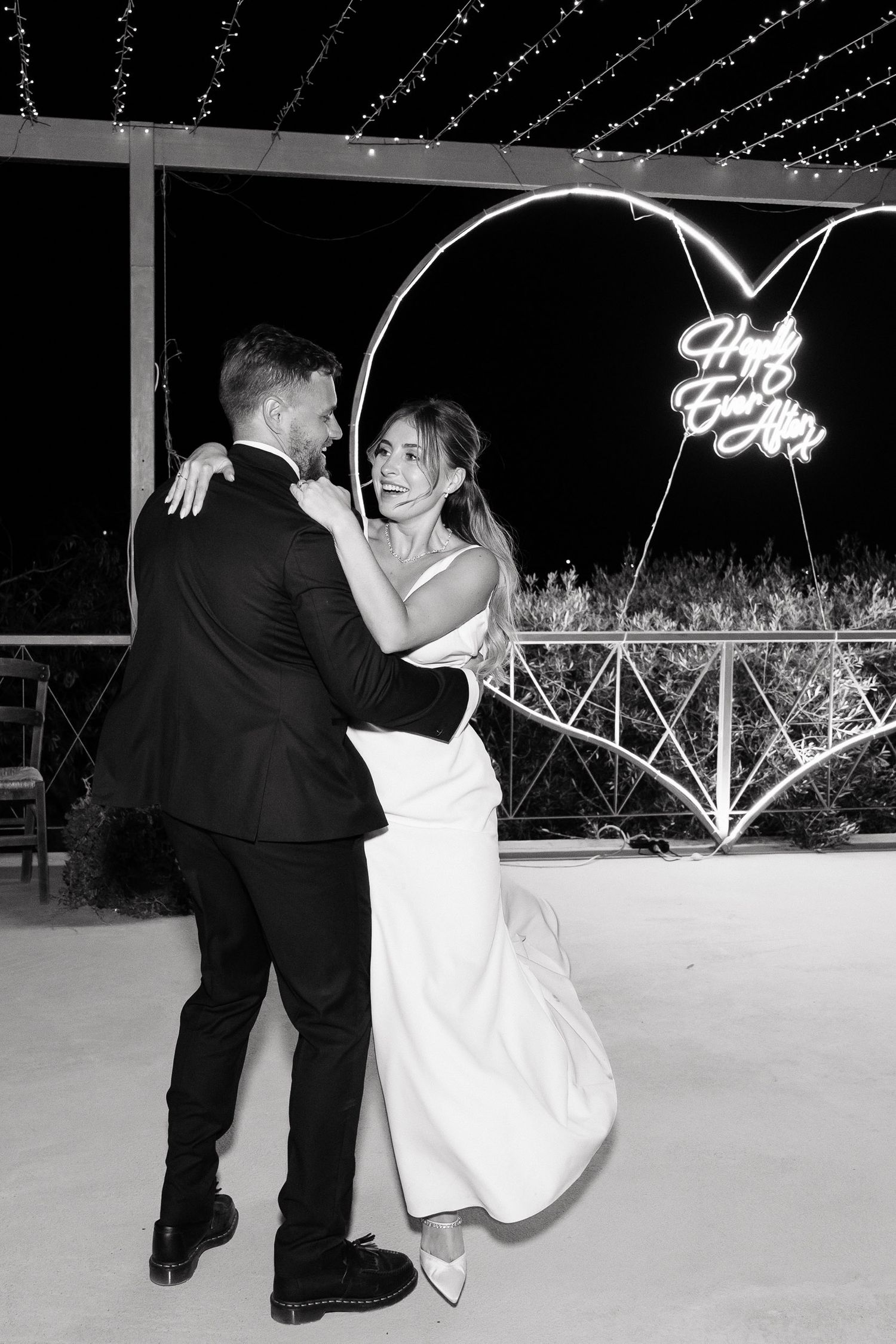 A romantic dance sequence showing a couple performing a dip move on a dance floor in black and white photography.