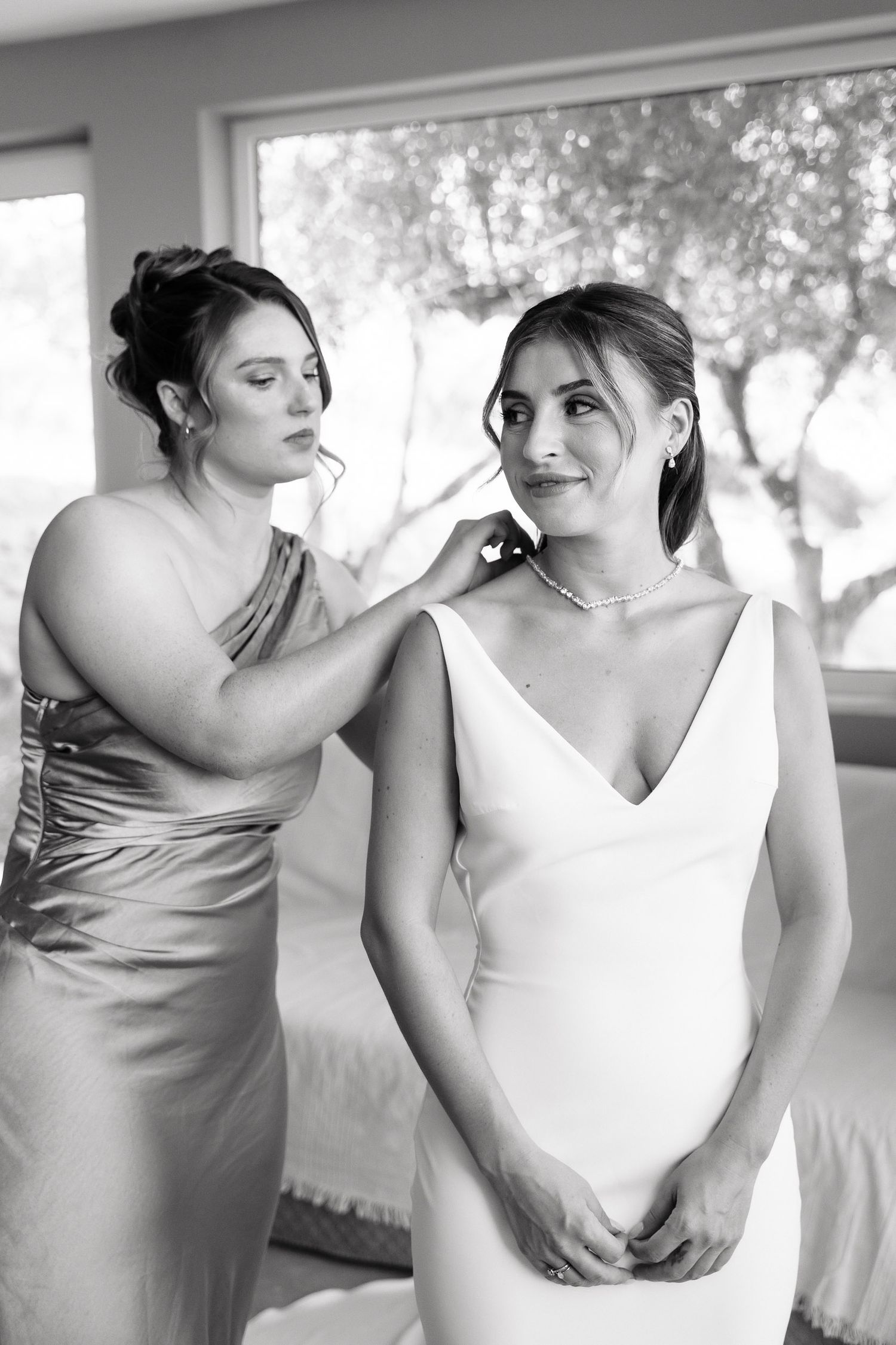 Two people in formal attire share an intimate moment while dancing together in black and white photography.