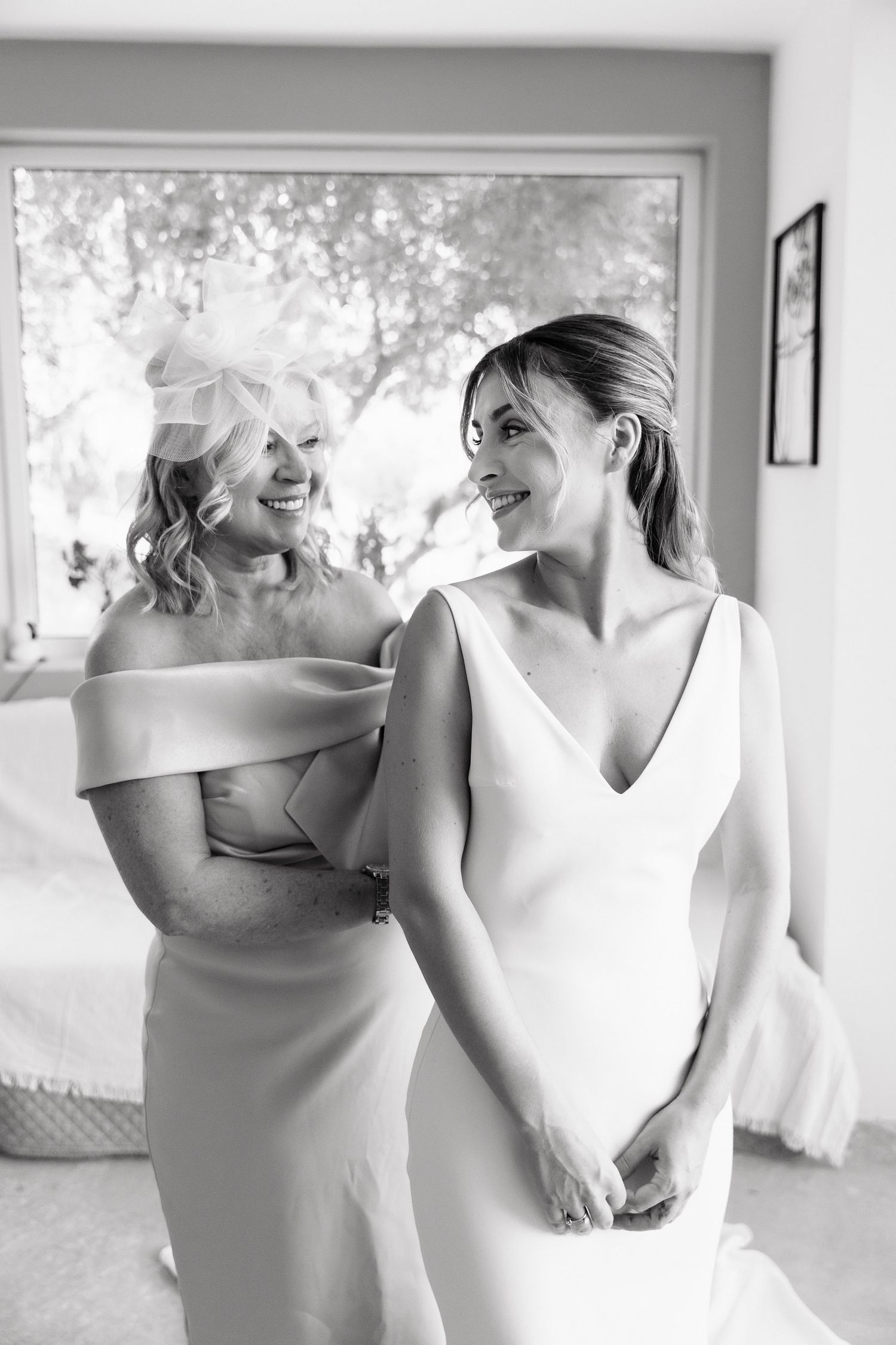 Black and white photo series showing emotional moments between wedding party members in elegant white dresses.