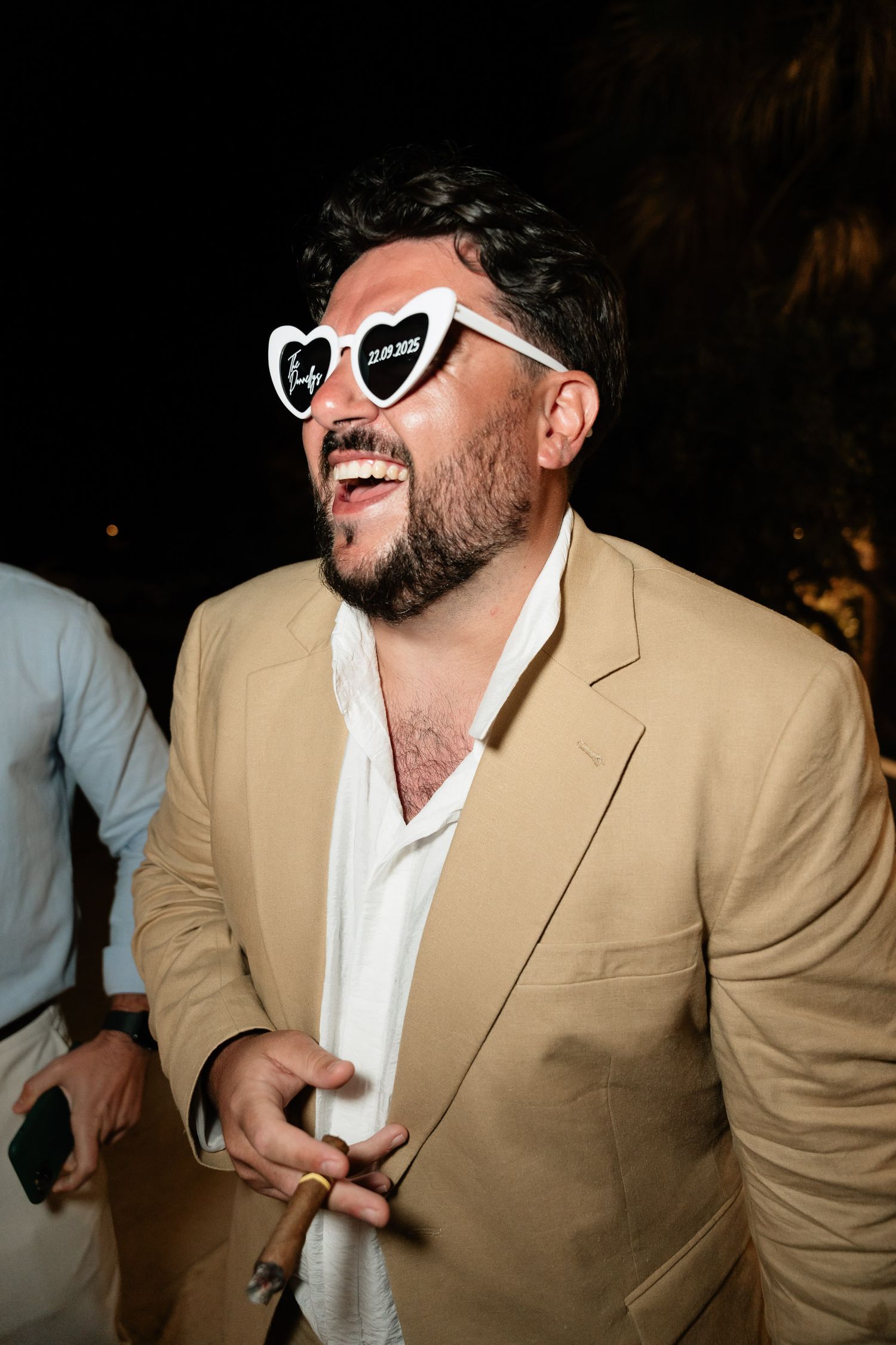 A person in a tan blazer and white shirt wearing sunglasses poses in a sequence of four similar photos.