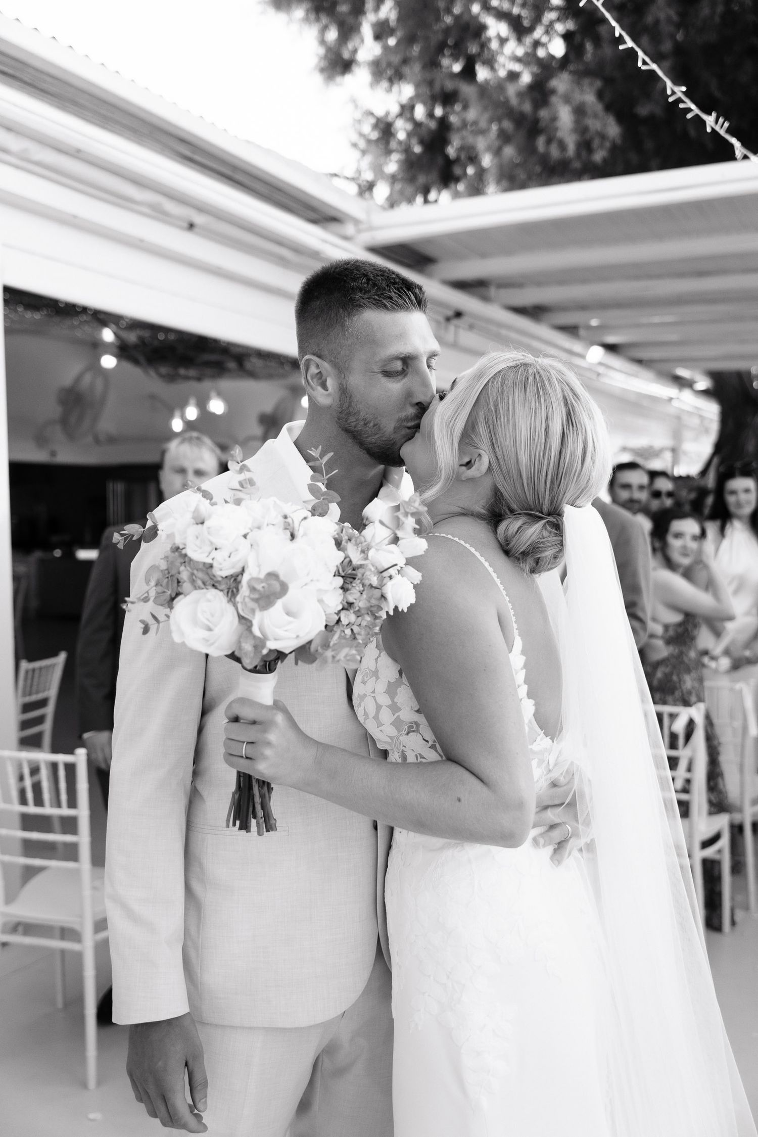 A romantic black and white wedding photo series showing tender moments between a couple embracing during their ceremony.