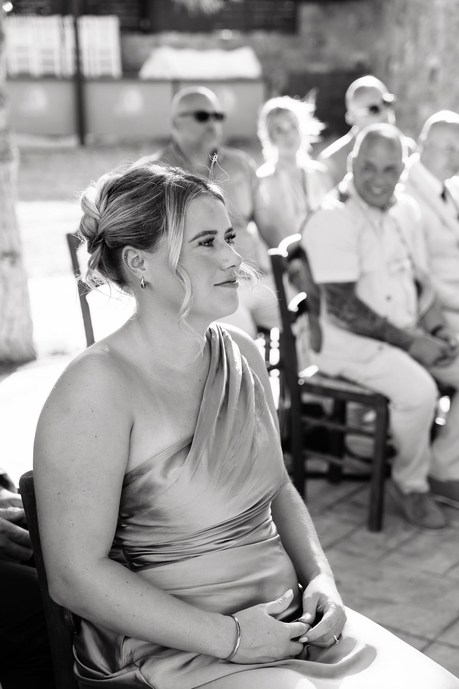 A sequence of black and white photos showing a bridesmaid in a strapless dress during an outdoor wedding reception.