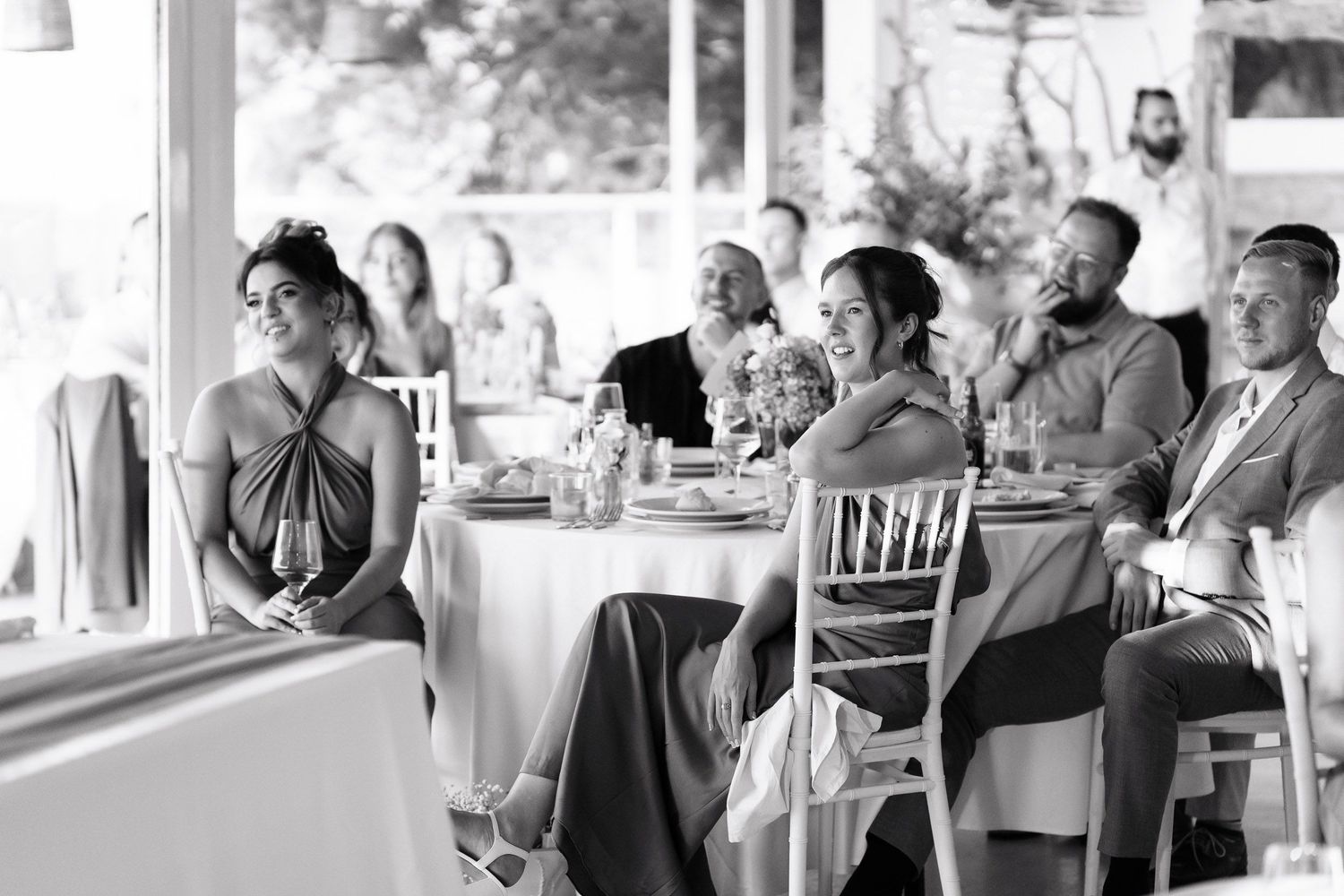 A black and white photo sequence showing wedding guests embracing and celebrating during a reception.