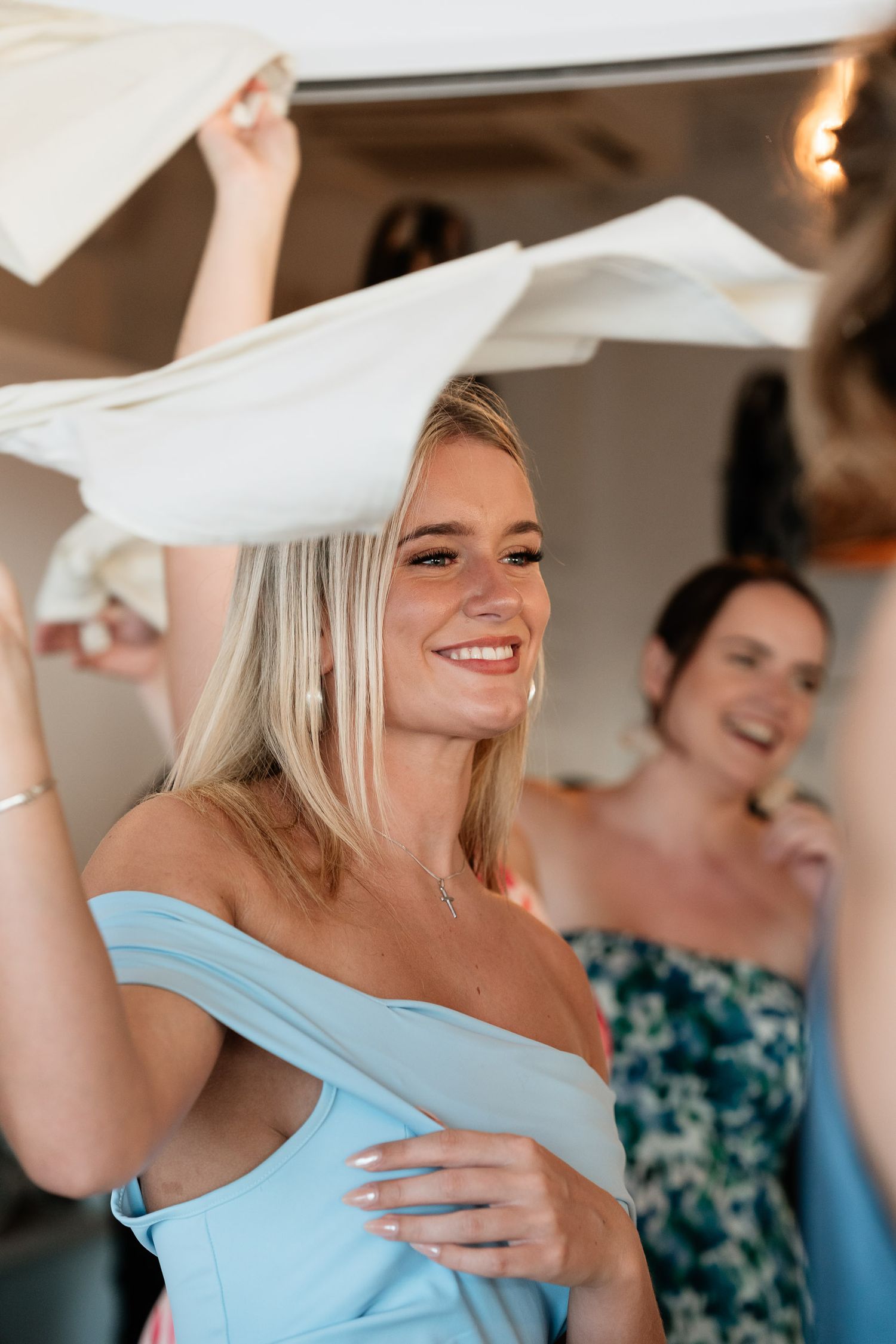 People in formal attire share a joyful moment during a celebration with flowing white fabric and blue accents.