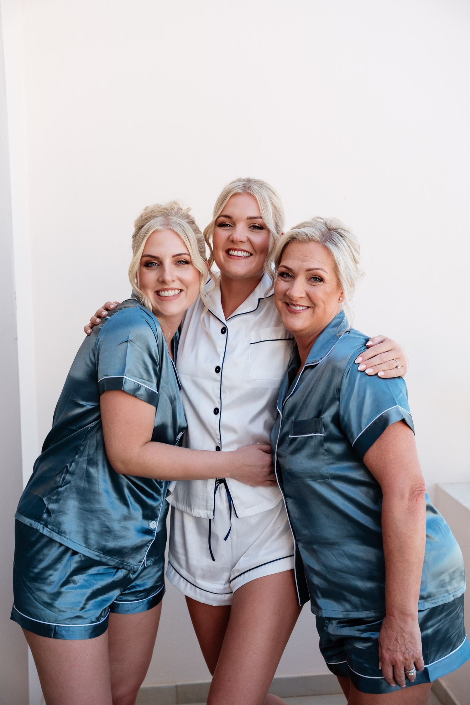 Three people wearing blue and white casual outfits pose together in a series of candid shots against a white background.