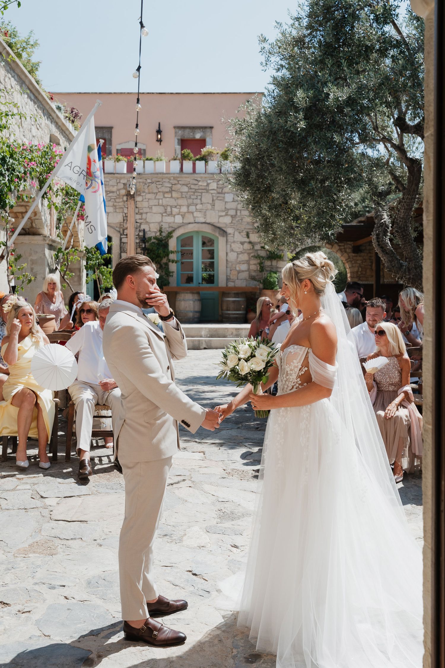 A joyful wedding celebration sequence showing dancing and festivities in a sunny outdoor courtyard with stone walls.