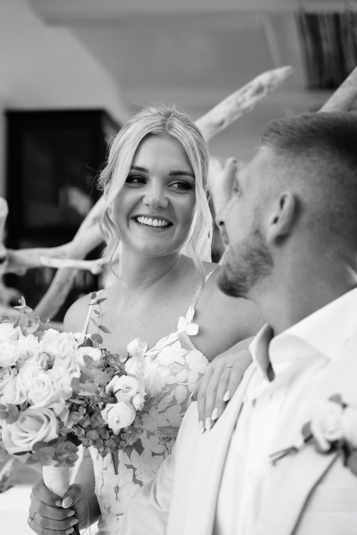 Black and white wedding photo series showing joyful moments and white rose bouquets during a celebration.