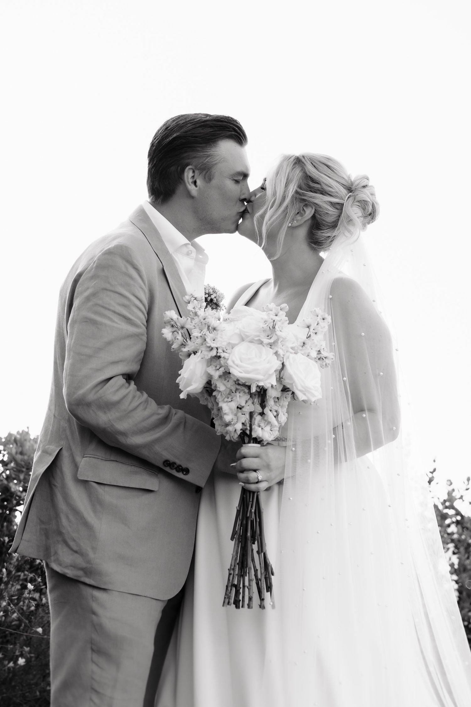 A romantic moment captured in black and white between a couple during their wedding celebration.