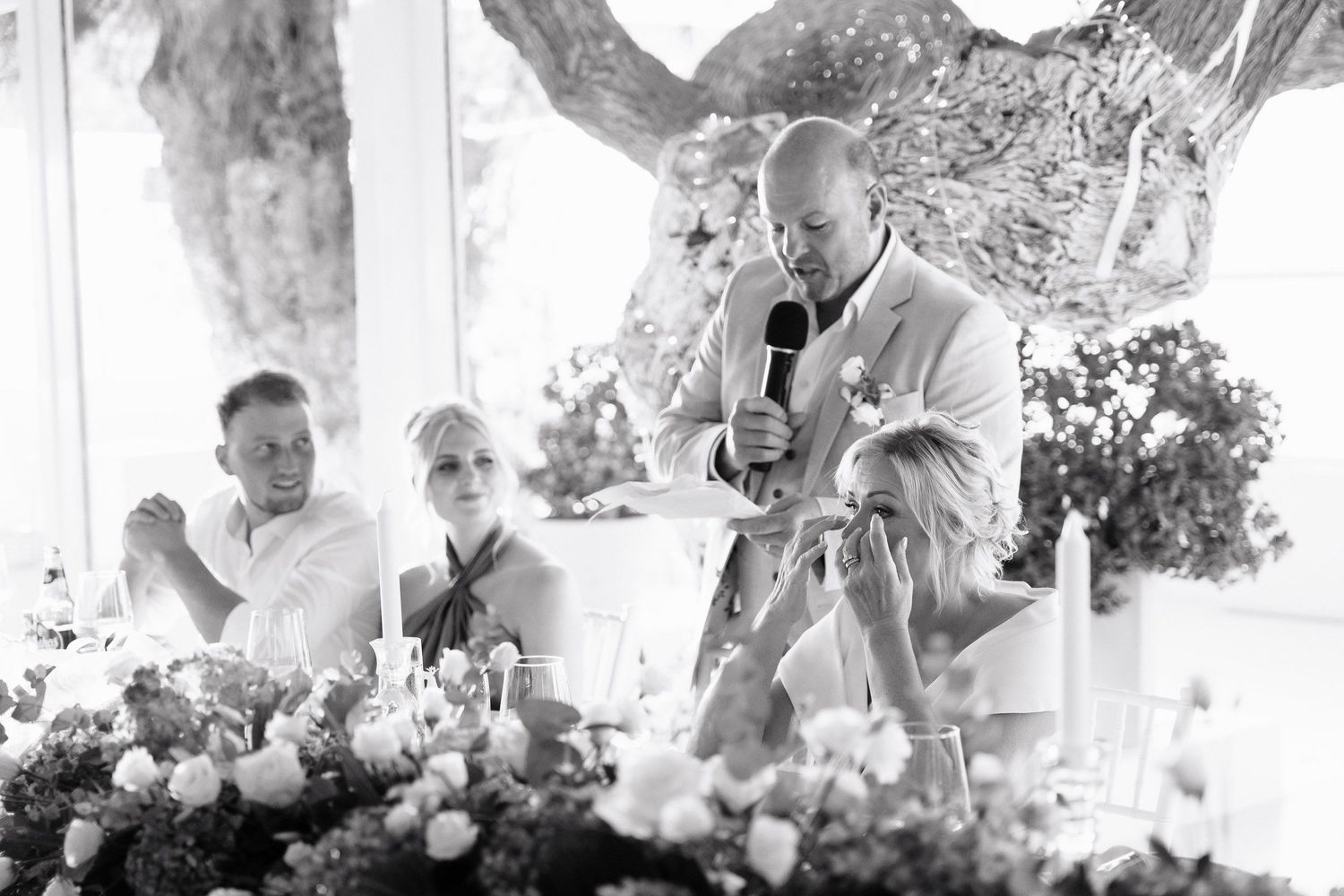 A black and white photo collage of wedding reception moments showing guests dining and celebrating under outdoor trees.