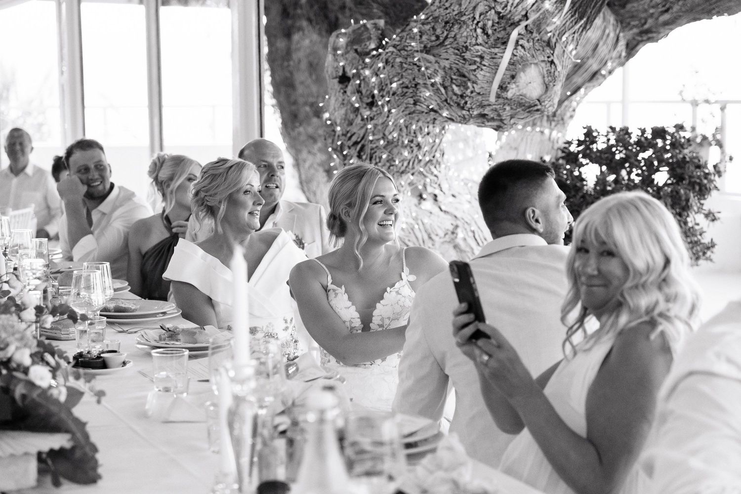 Wedding guests dance and celebrate together during a joyful reception party outdoors.