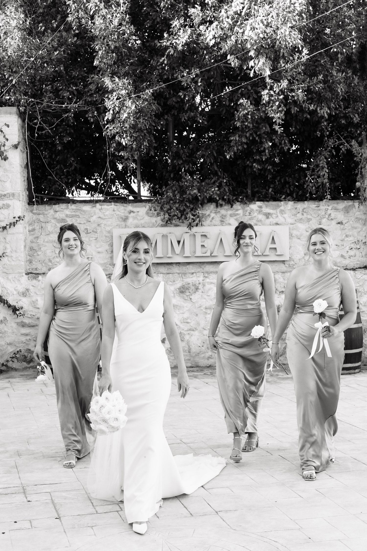 A sequence of three black and white wedding party photos showing bridesmaids in matching gray dresses walking outdoors.