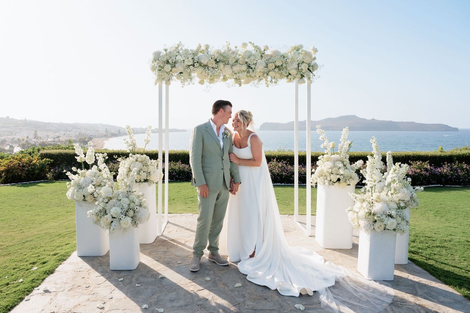 A couple shares an intimate moment during their outdoor wedding ceremony with scenic mountain views in the background.