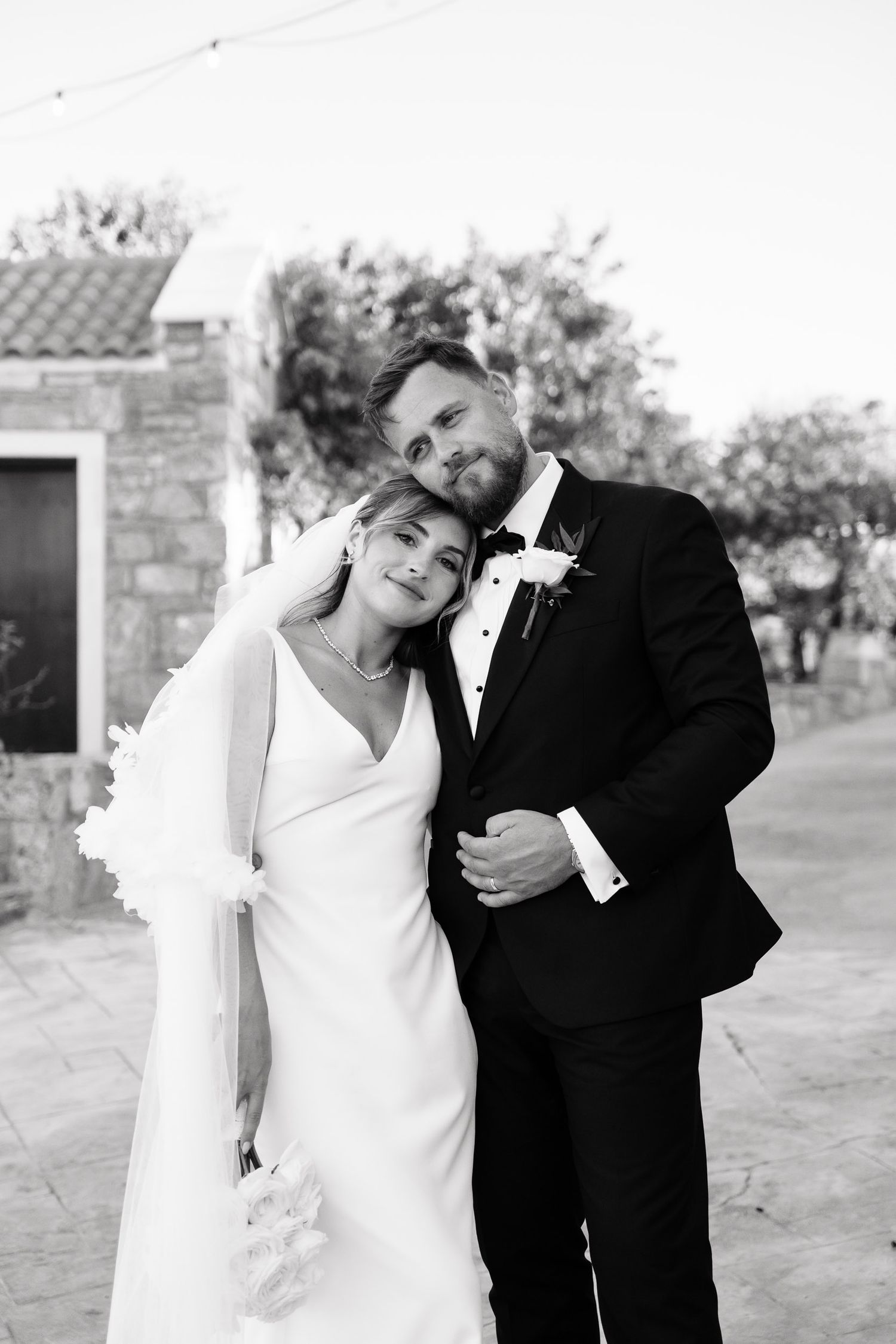 A series of black and white wedding photos showing playful poses between a bride and groom outdoors.