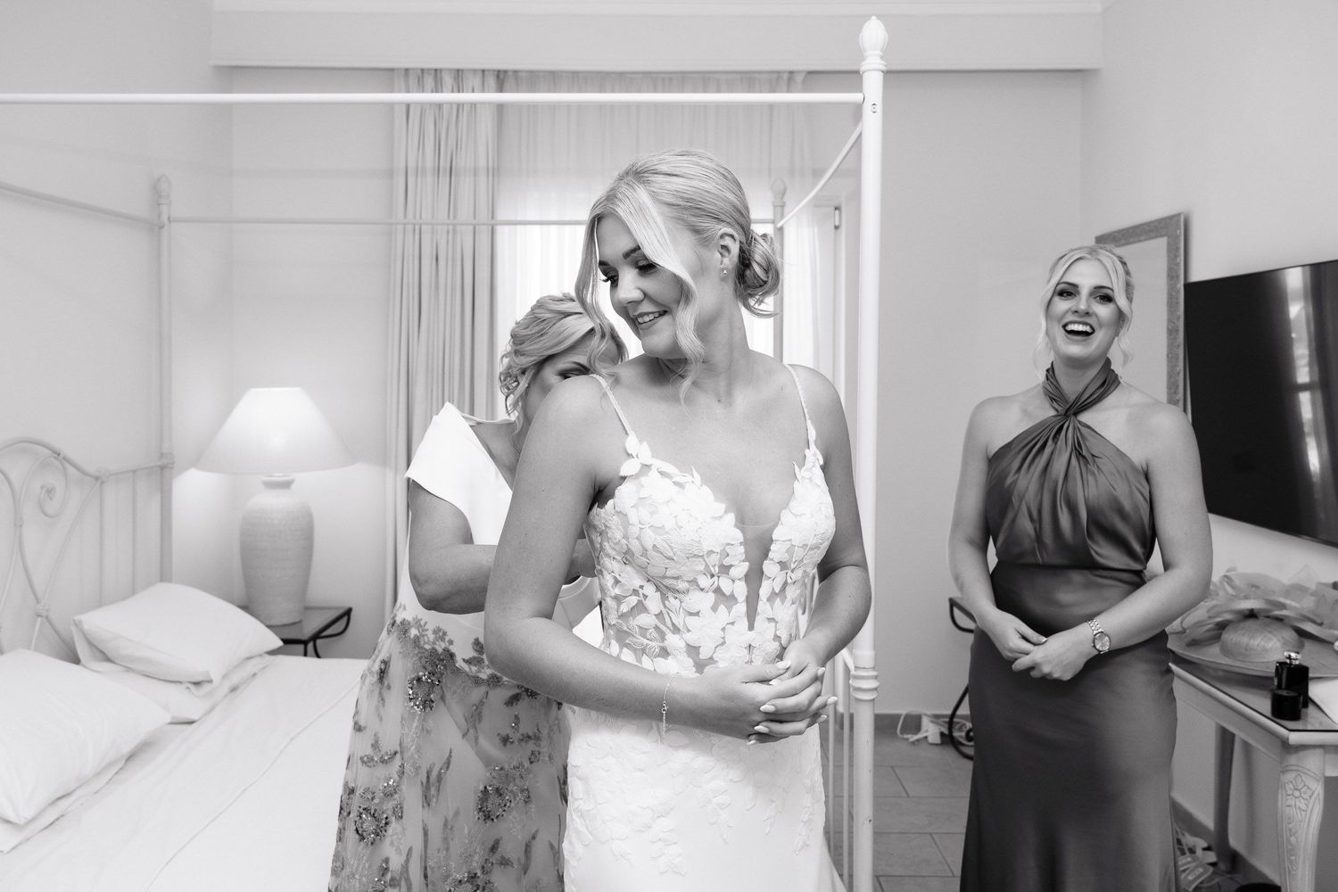 Wedding preparation scene with people getting ready in a bright white room.
