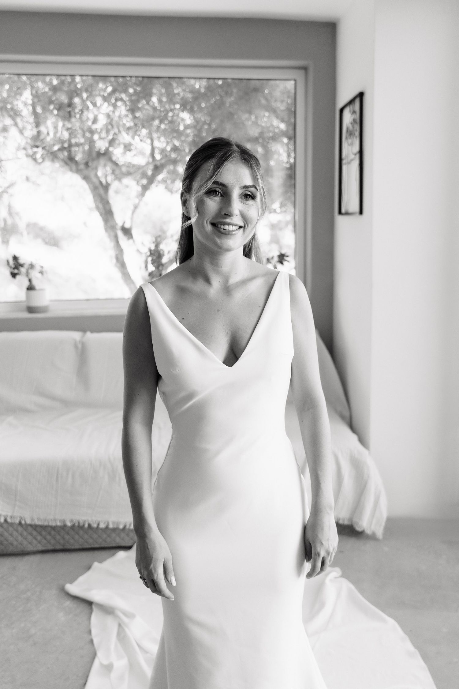 A sequence of black and white photos showing a bride in a sleek white wedding dress with flowing details.