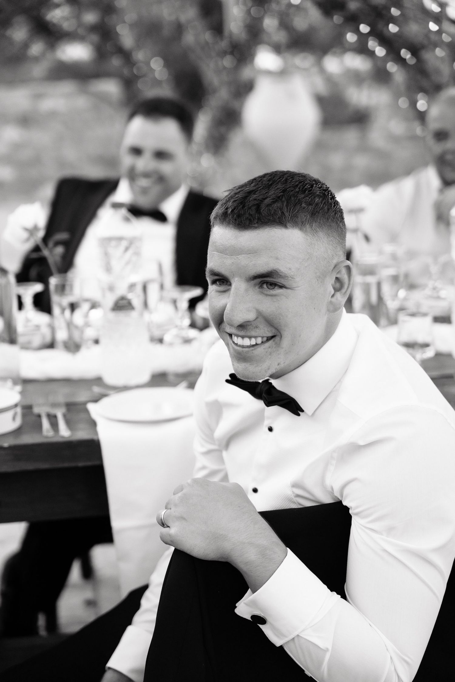 Black and white candid photos of guests laughing and enjoying themselves at a formal event reception.