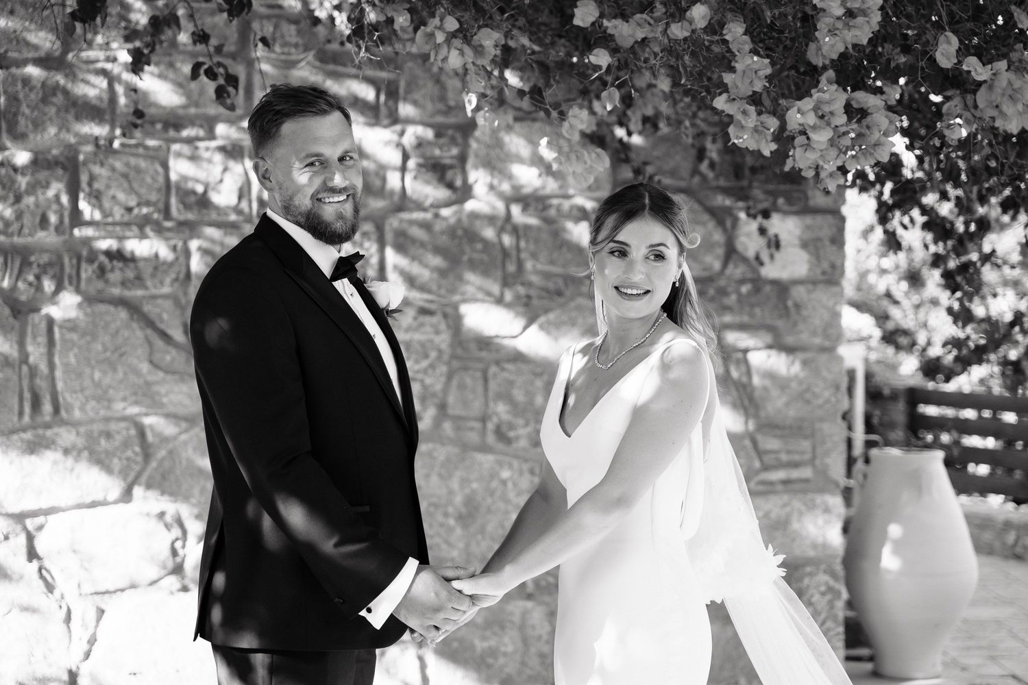 A black and white wedding photo collage showing romantic moments between newlyweds in an outdoor setting.