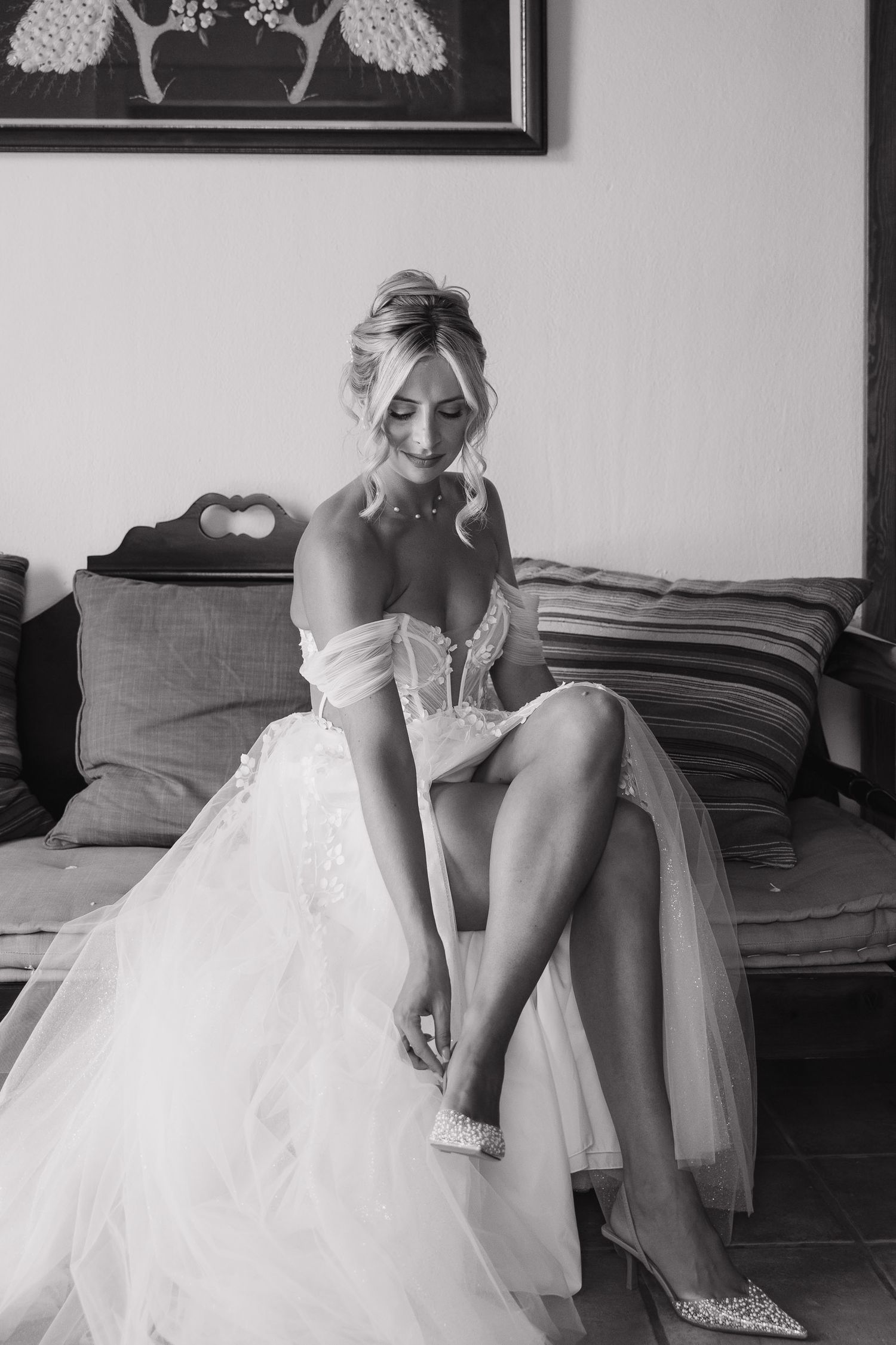 A sequence of black and white photos showing a bride getting ready and putting on shoes before her wedding ceremony.