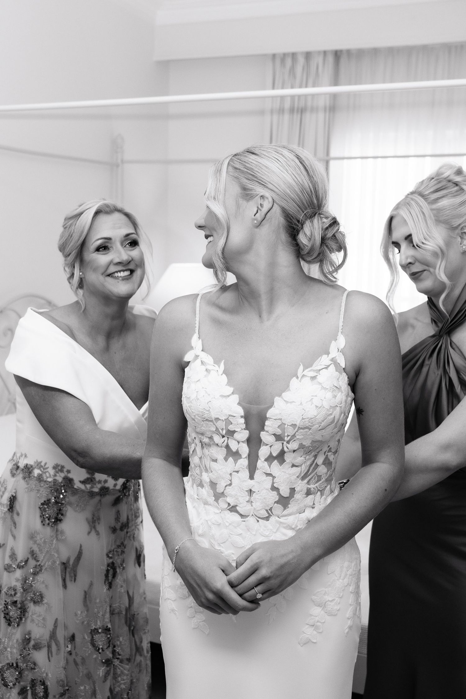 A series of black and white photos showing joyful moments between people embracing and laughing at a wedding celebration.