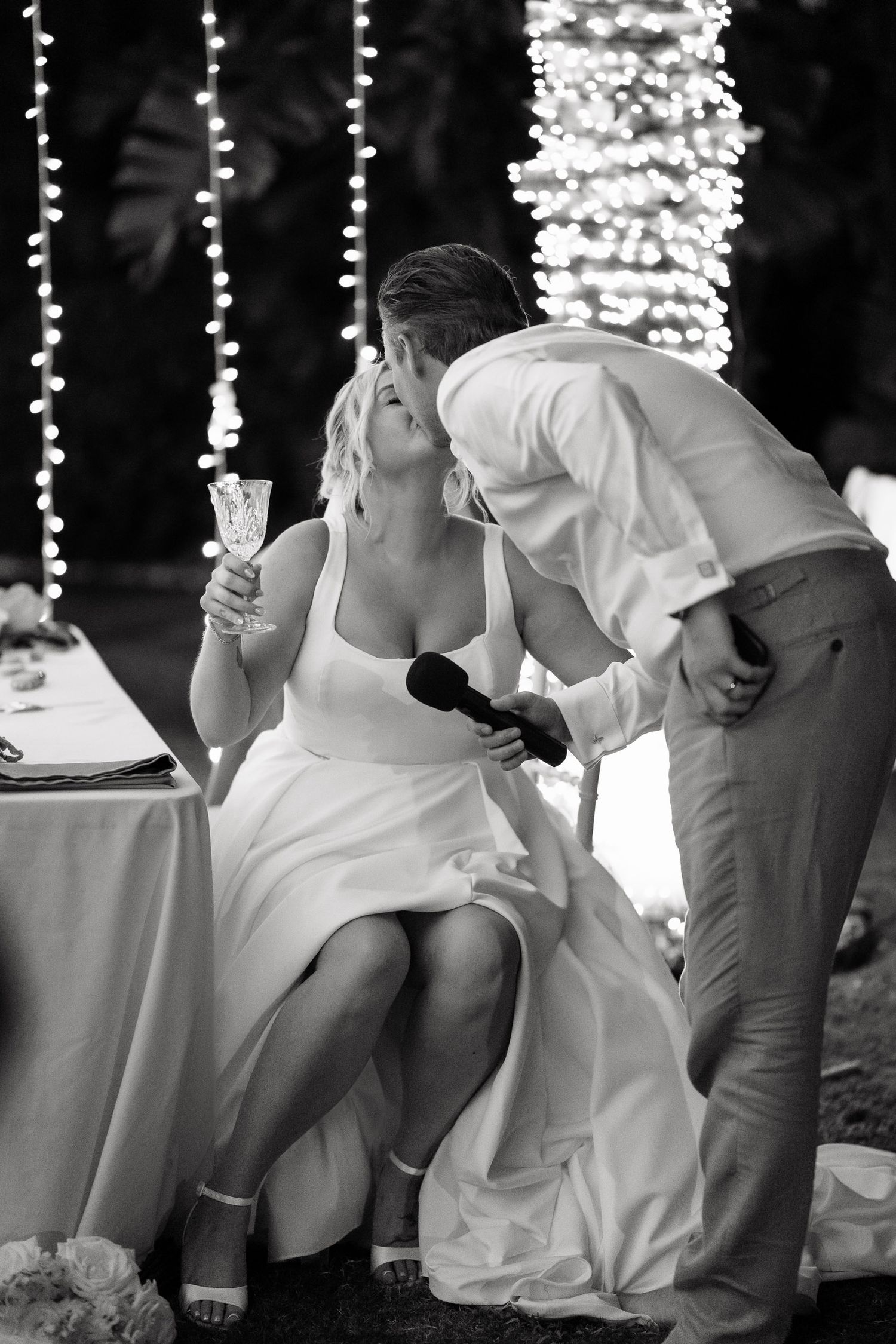 A black and white photo series showing guests seated at a wedding reception enjoying drinks and conversation.