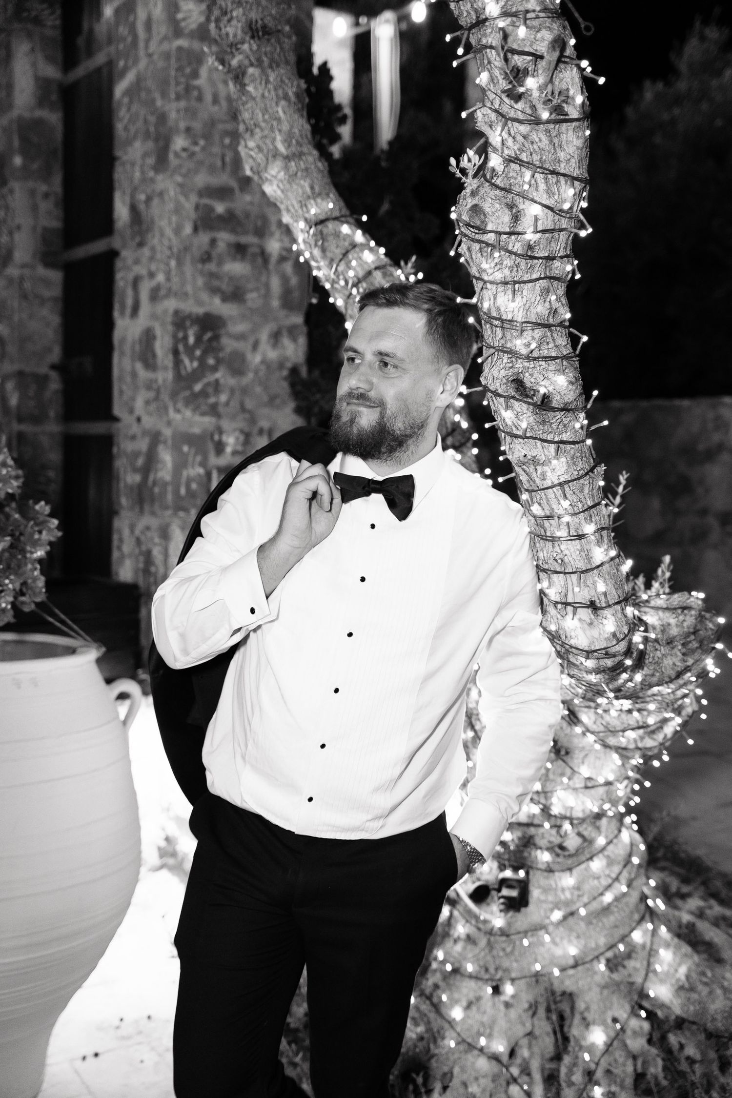 A black and white photo series shows a person in formal attire dancing and posing against a textured wall with trees.