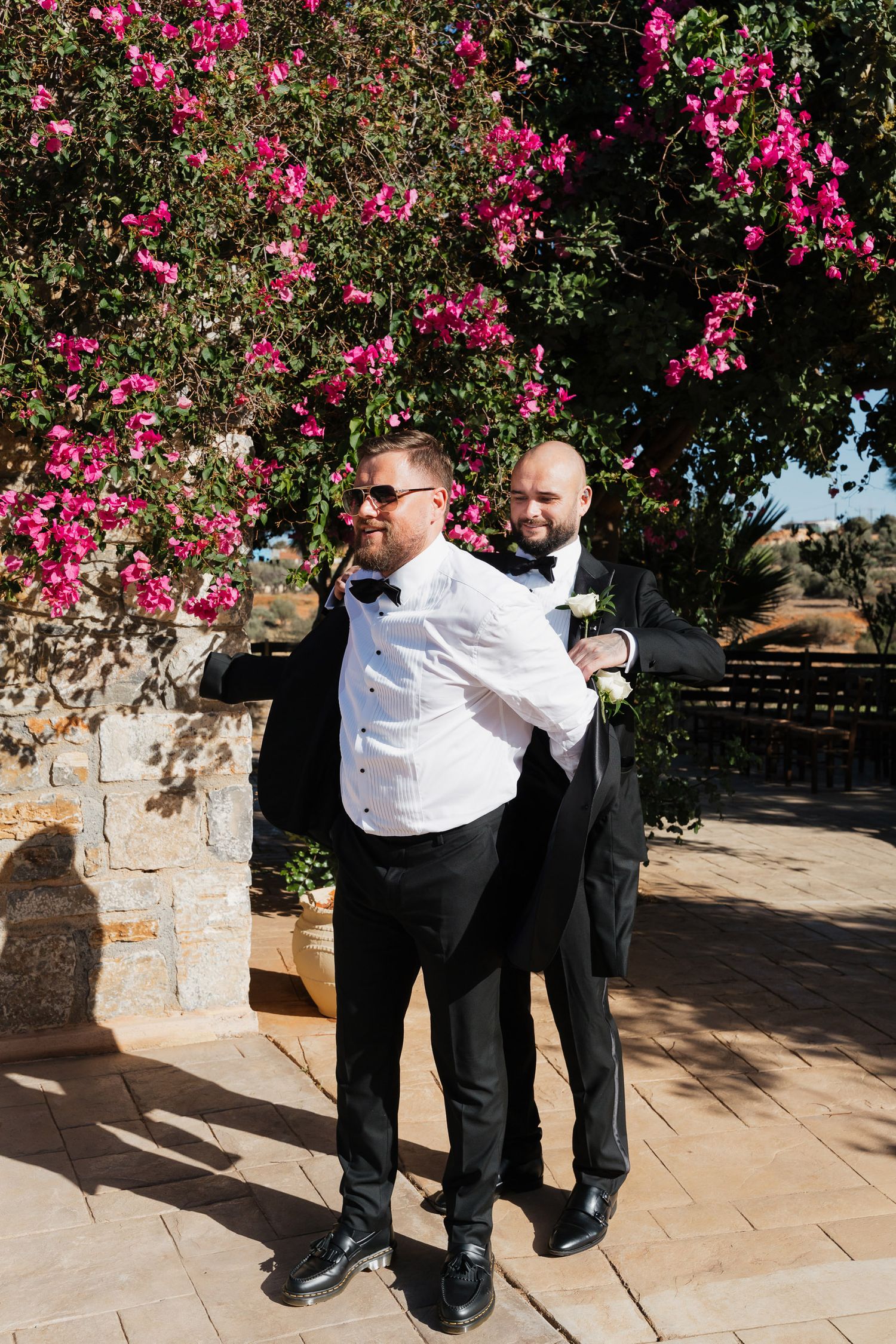 A sequence of dance moves shown against a backdrop of vibrant pink bougainvillea flowers and stone walls.