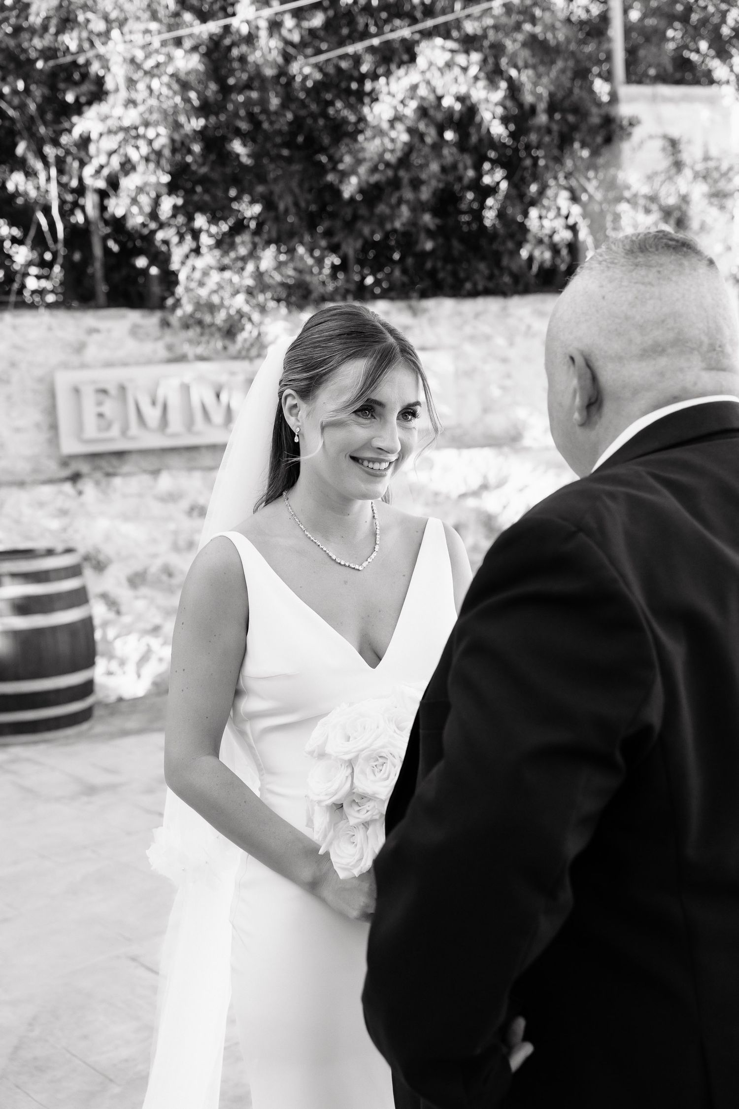 Black and white wedding photos show tender moments between bride and groom during outdoor celebration.