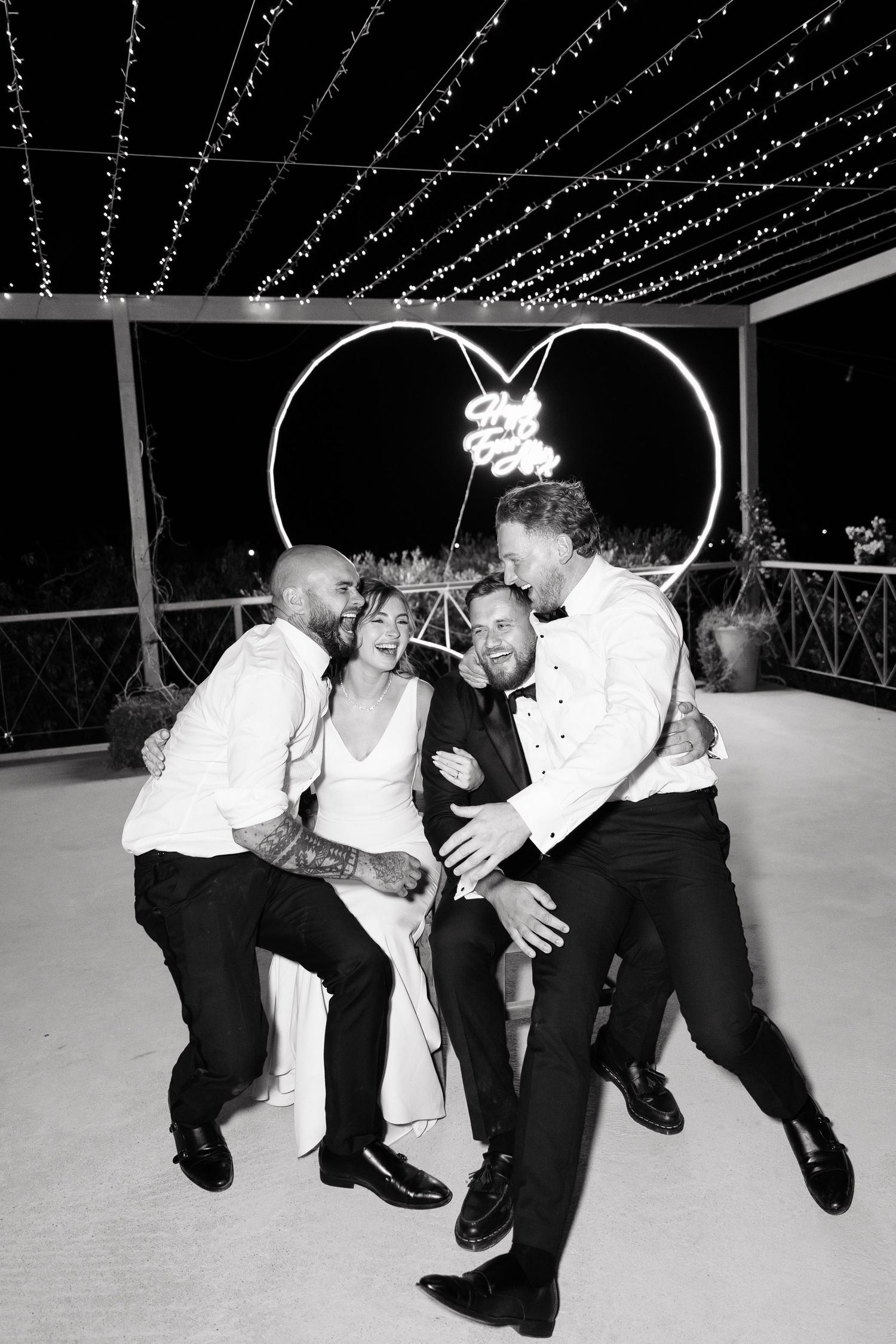A sequence of black and white photos showing people dancing and dipping on a dance floor under string lights.