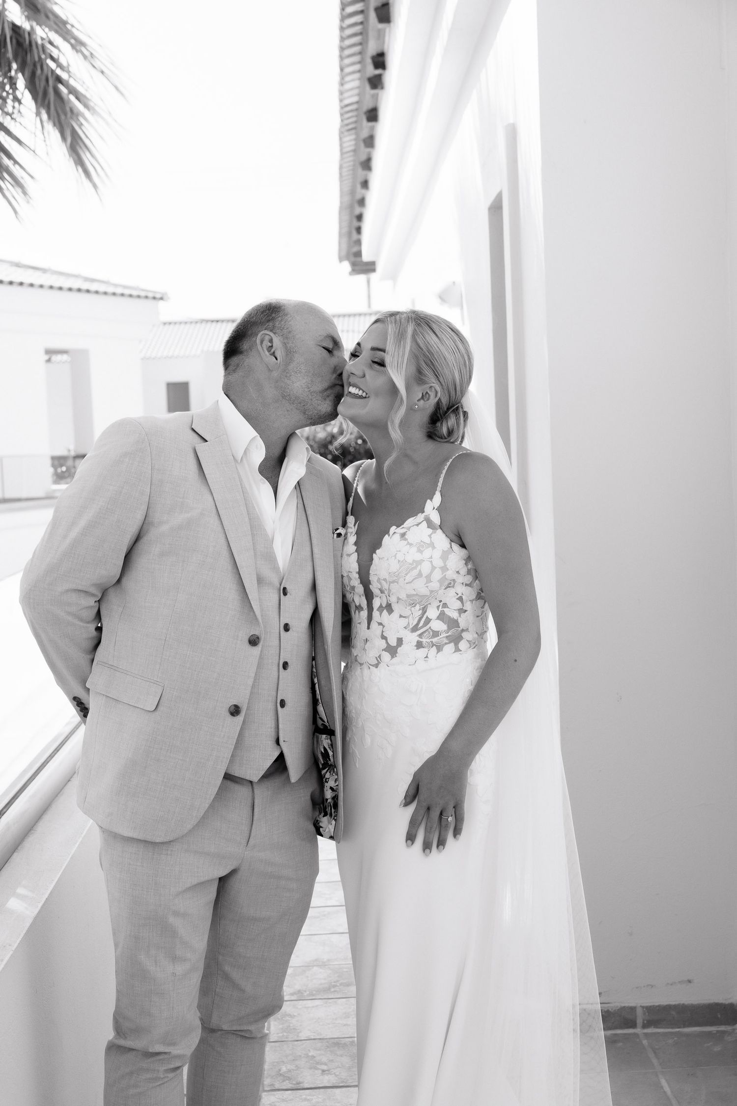 A romantic black and white photo series showing a couple in wedding attire sharing intimate moments on their special day.