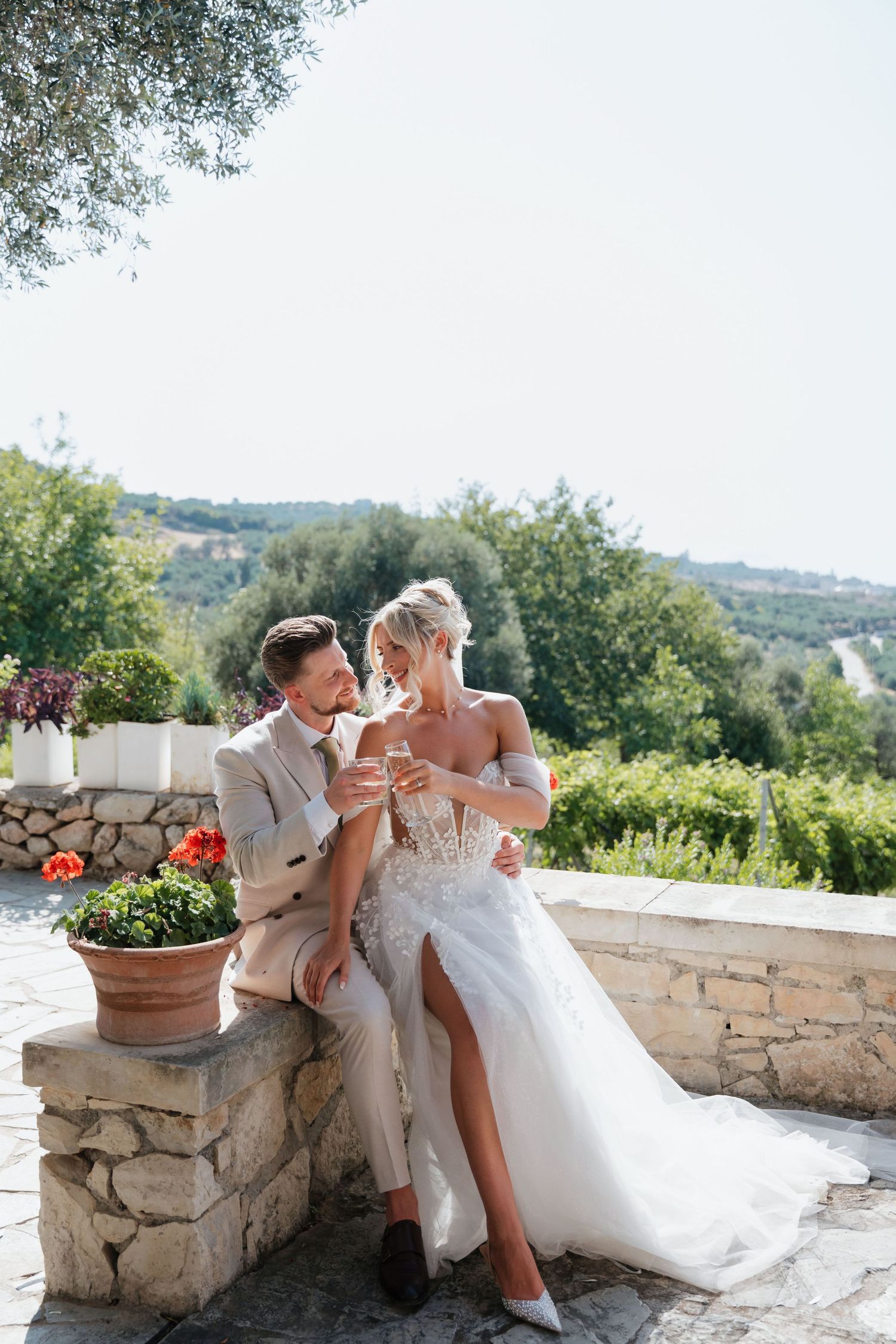 Couple sharing intimate moment on stone terrace overlooking scenic countryside.