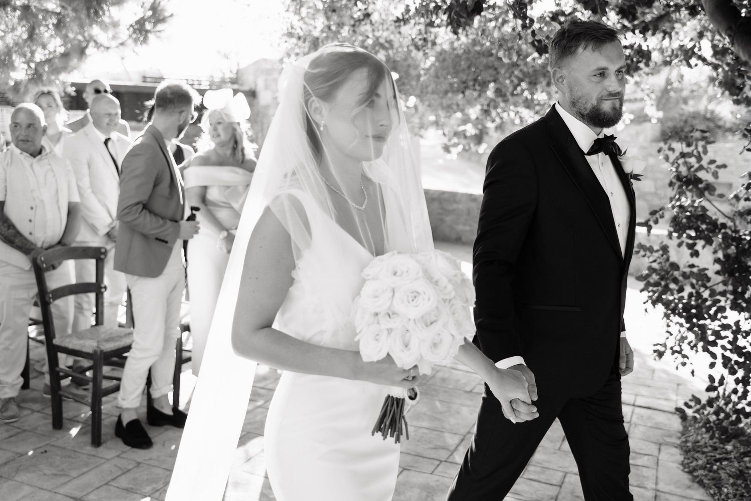 A series of candid black and white wedding photos showing intimate moments between couples during their celebration.