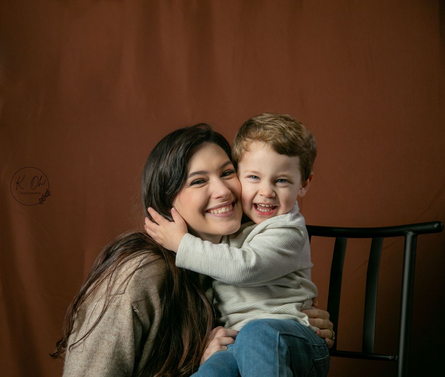 Candid family moments captured in studio against brown backdrop.