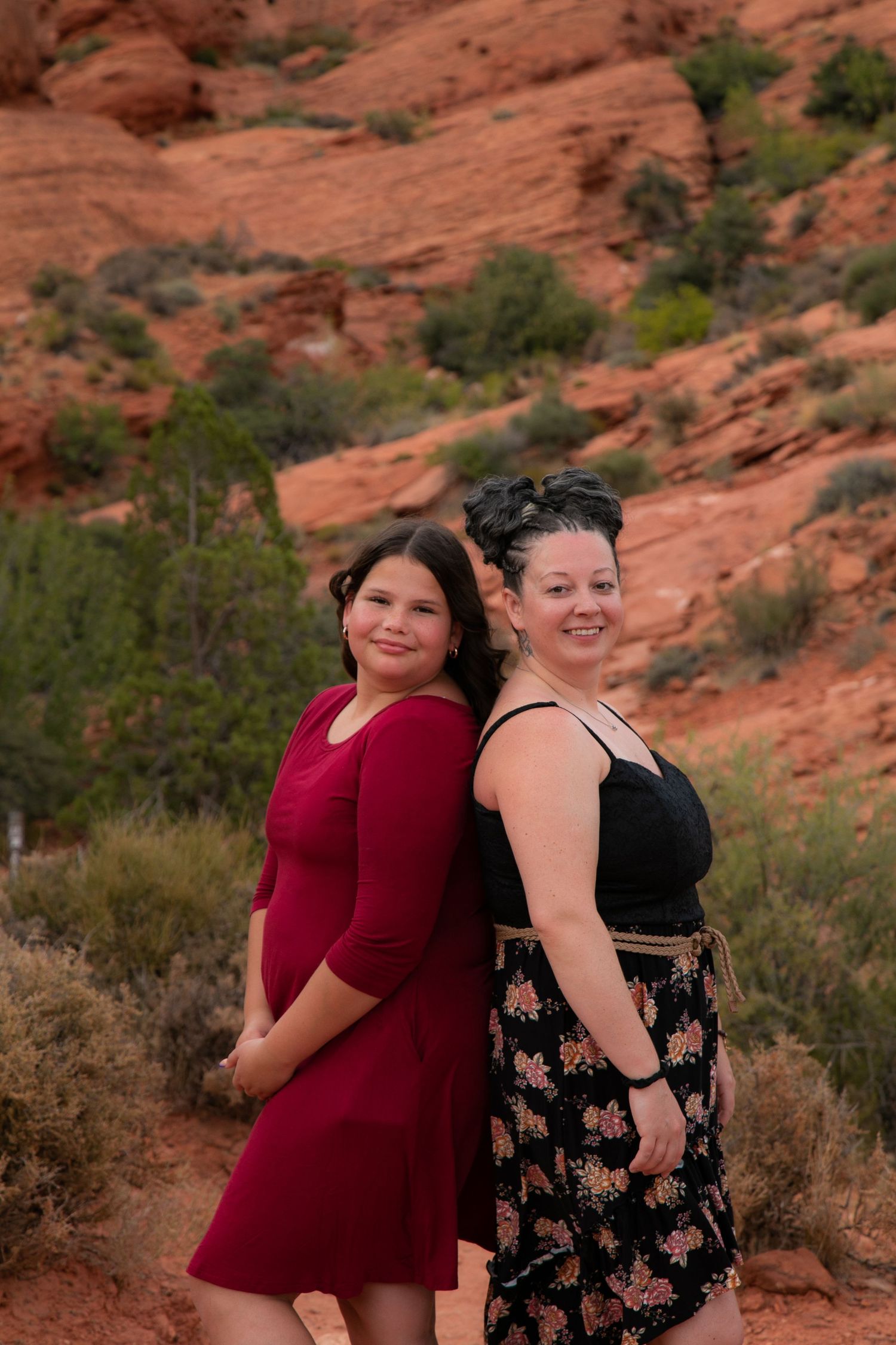 Candid poses of two people against scenic desert red rock backdrop.