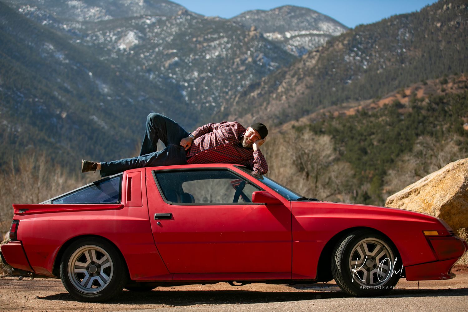 Multiple views of a red sports car photographed against a dramatic mountain landscape.