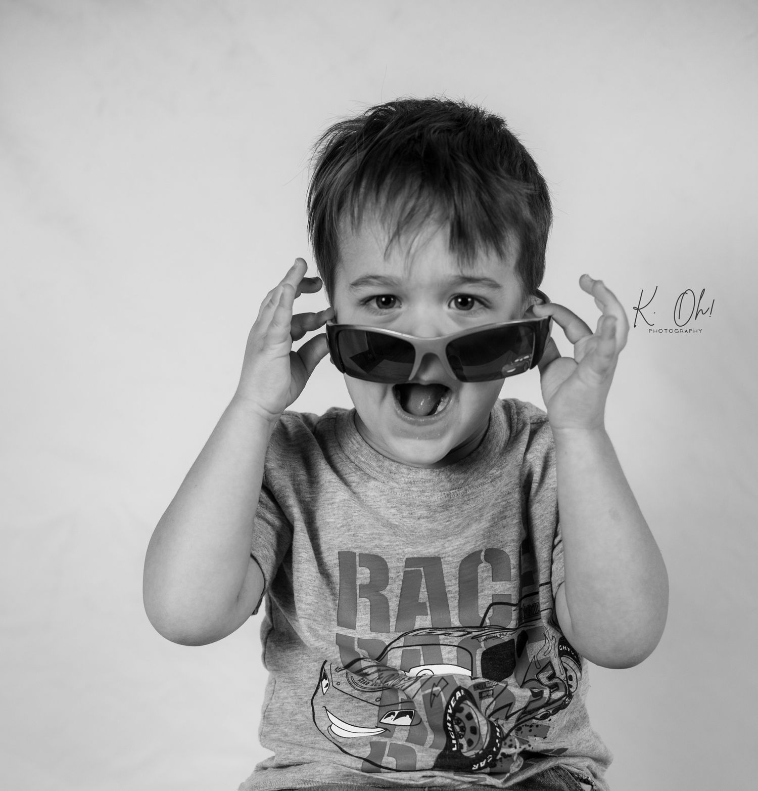 Black and white series of child playing with sunglasses.