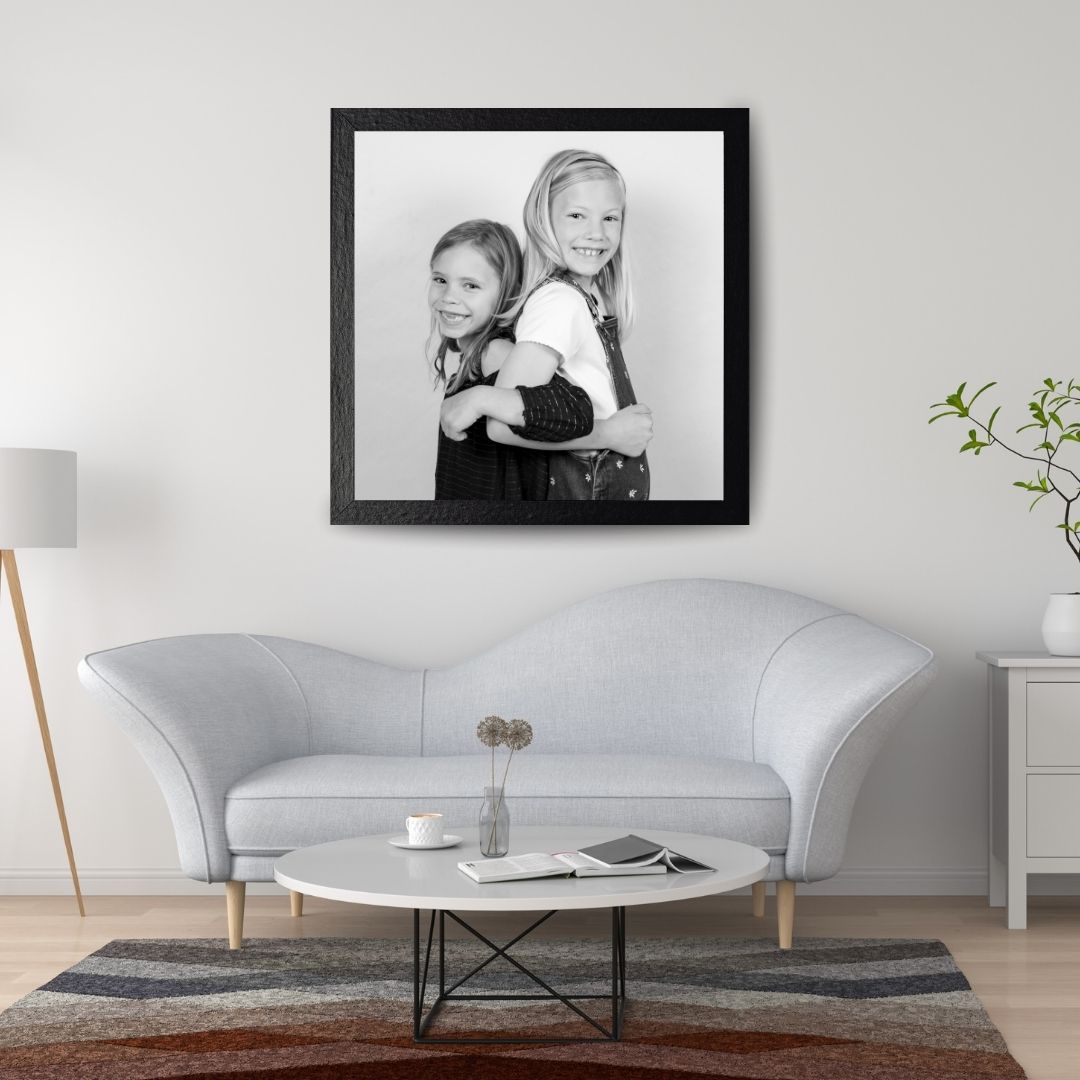 Contemporary living room with black and white framed artwork and grey sofa.