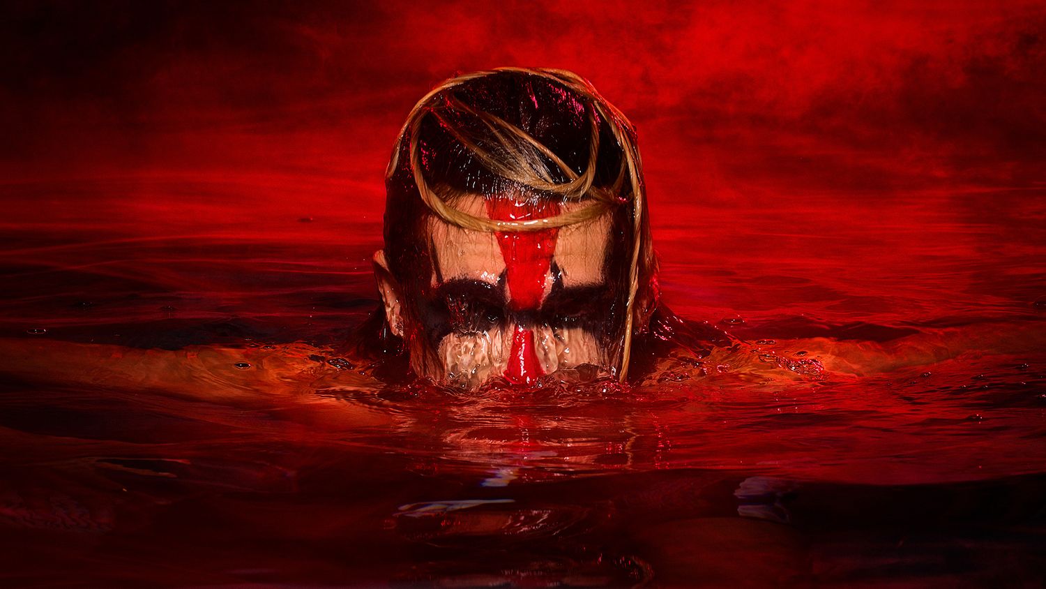 A dark silhouette emerges from blood-red water against an ominous crimson sky in a haunting horror scene.