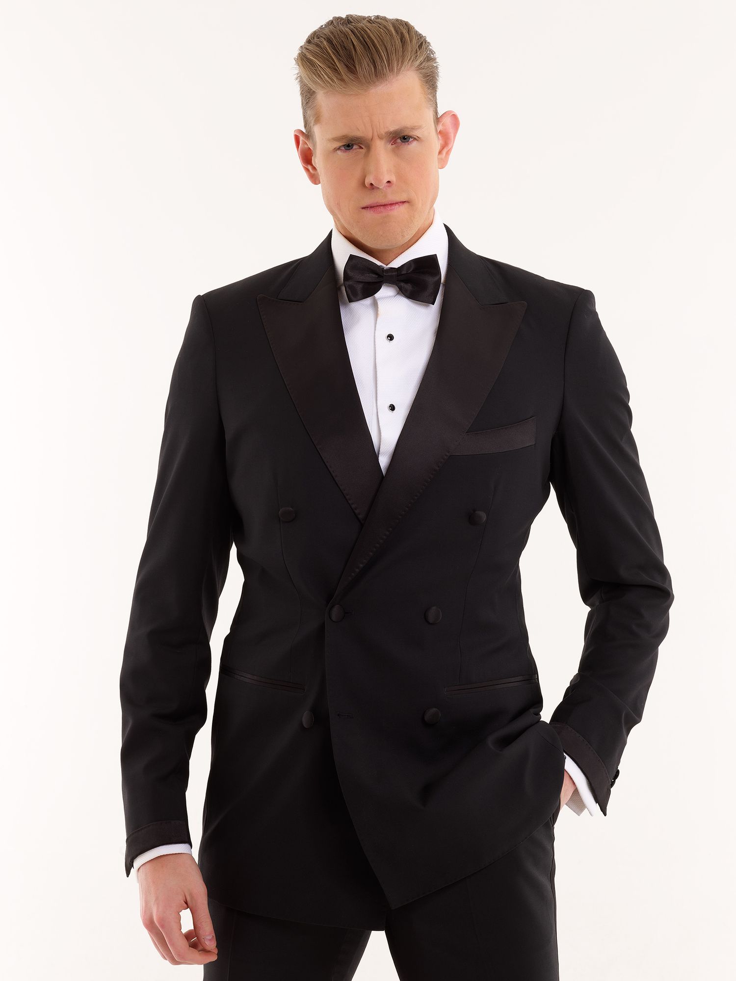 A well-fitted black double-breasted tuxedo with white dress shirt and bow tie on a light background.