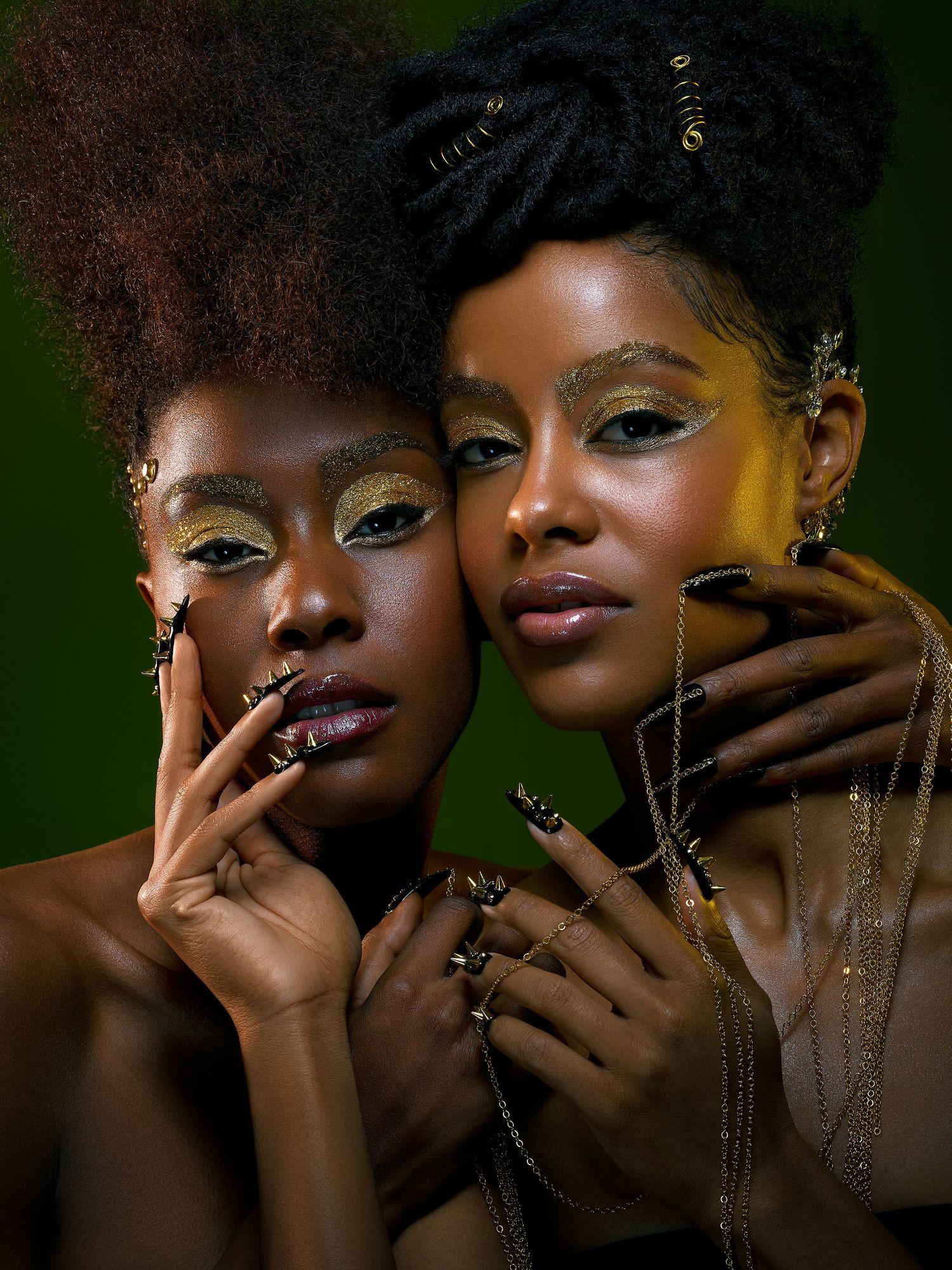 Beauty portrait with metallic gold eye makeup and accessories against dark green background.