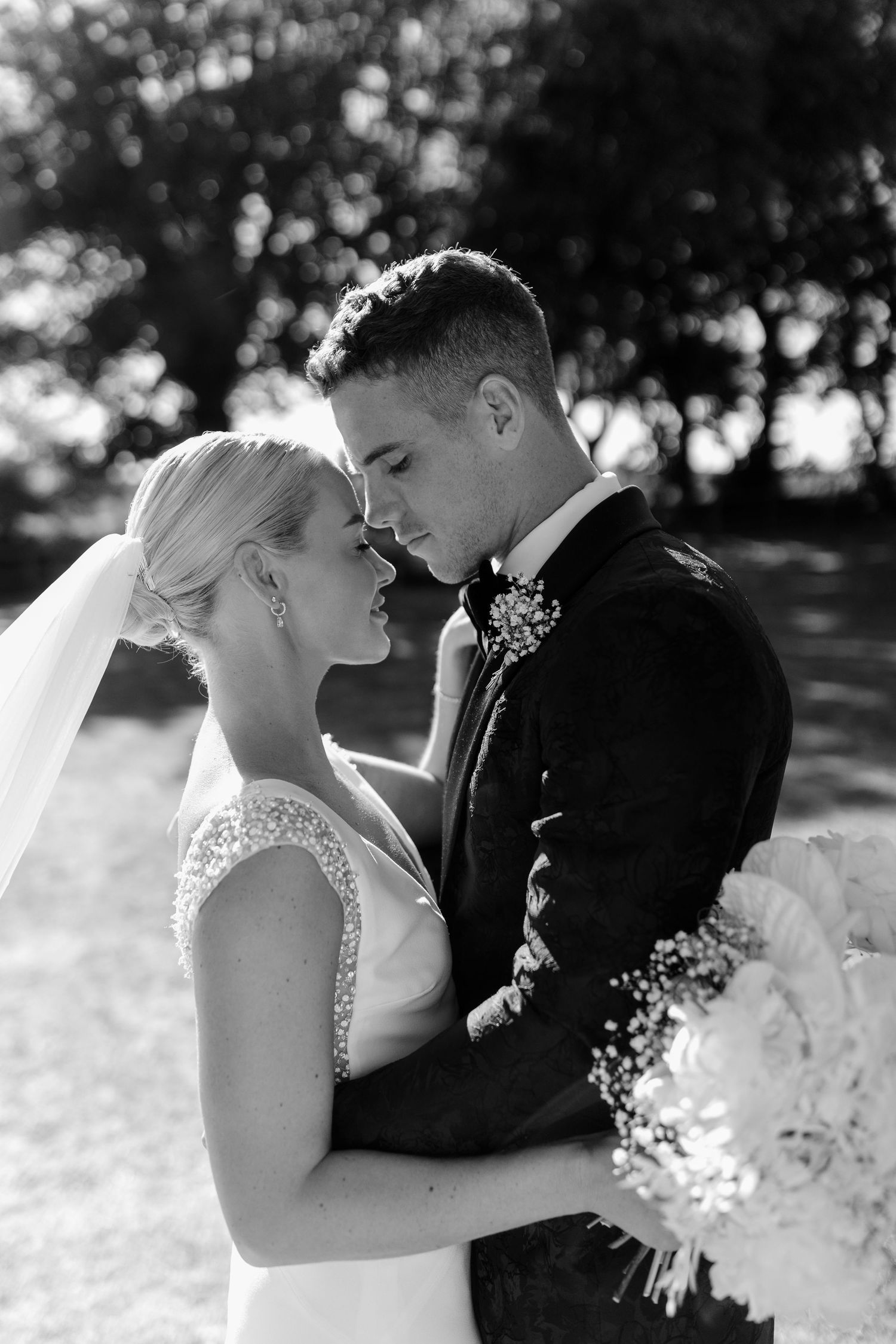 Intimate black and white wedding portraits showing tender moments between newlyweds.