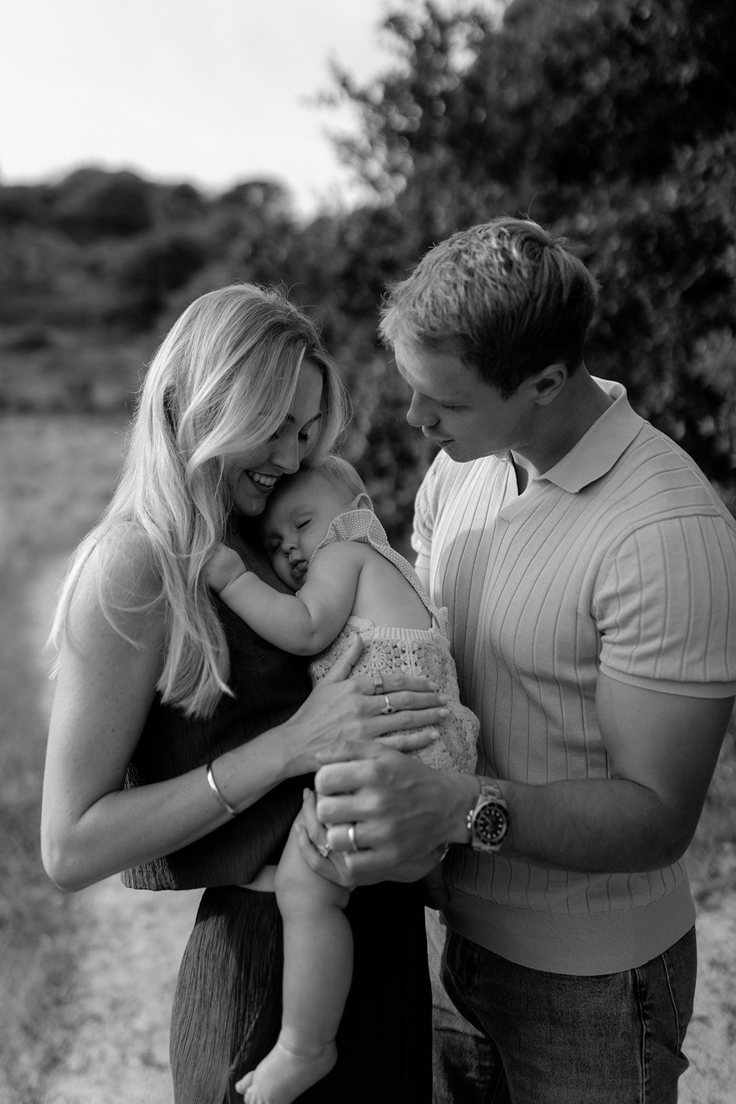 Black and white family portraits showing tender moments outdoors.