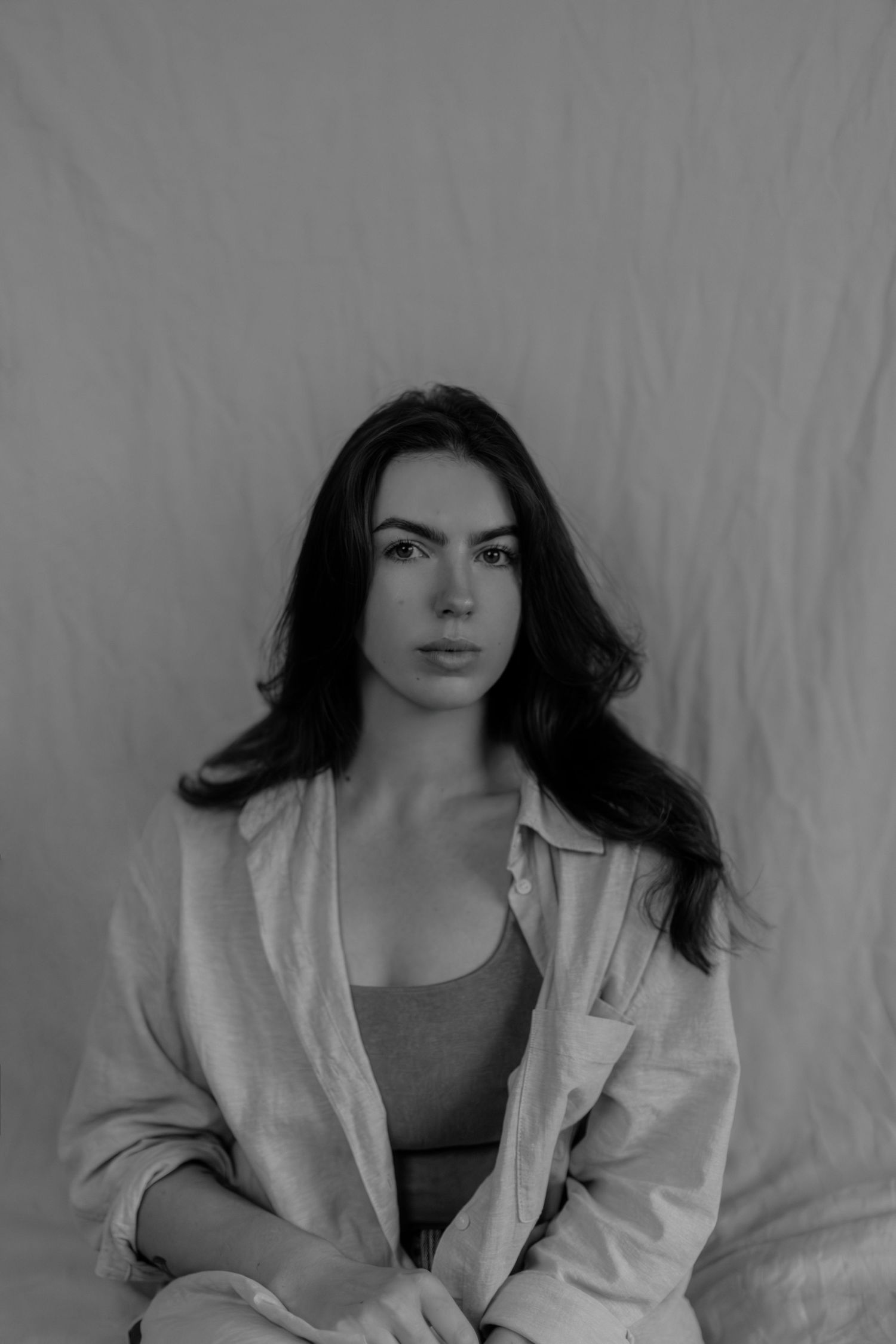 Stylish monochrome portraits featuring woman in white blazer with flowing hair.