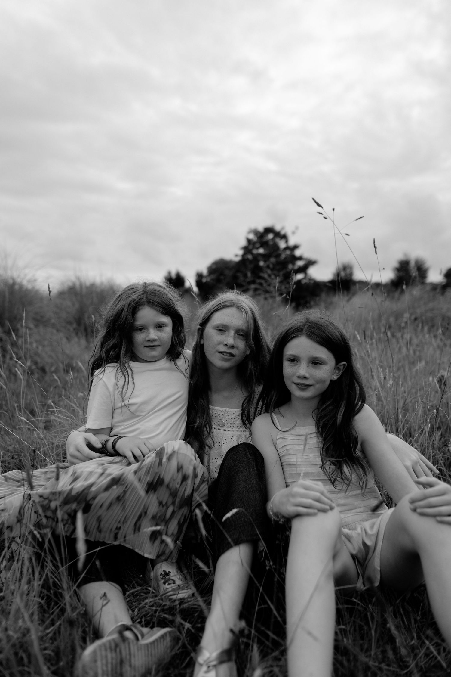 Sisters sitting in a meadow.