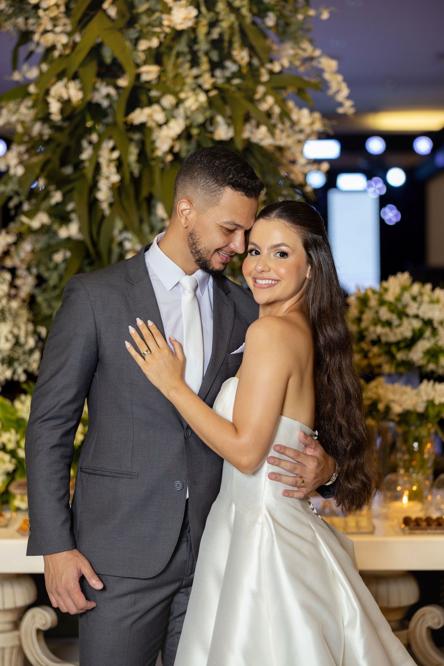 Elegant wedding reception setup with white floral arrangements and romantic lighting.