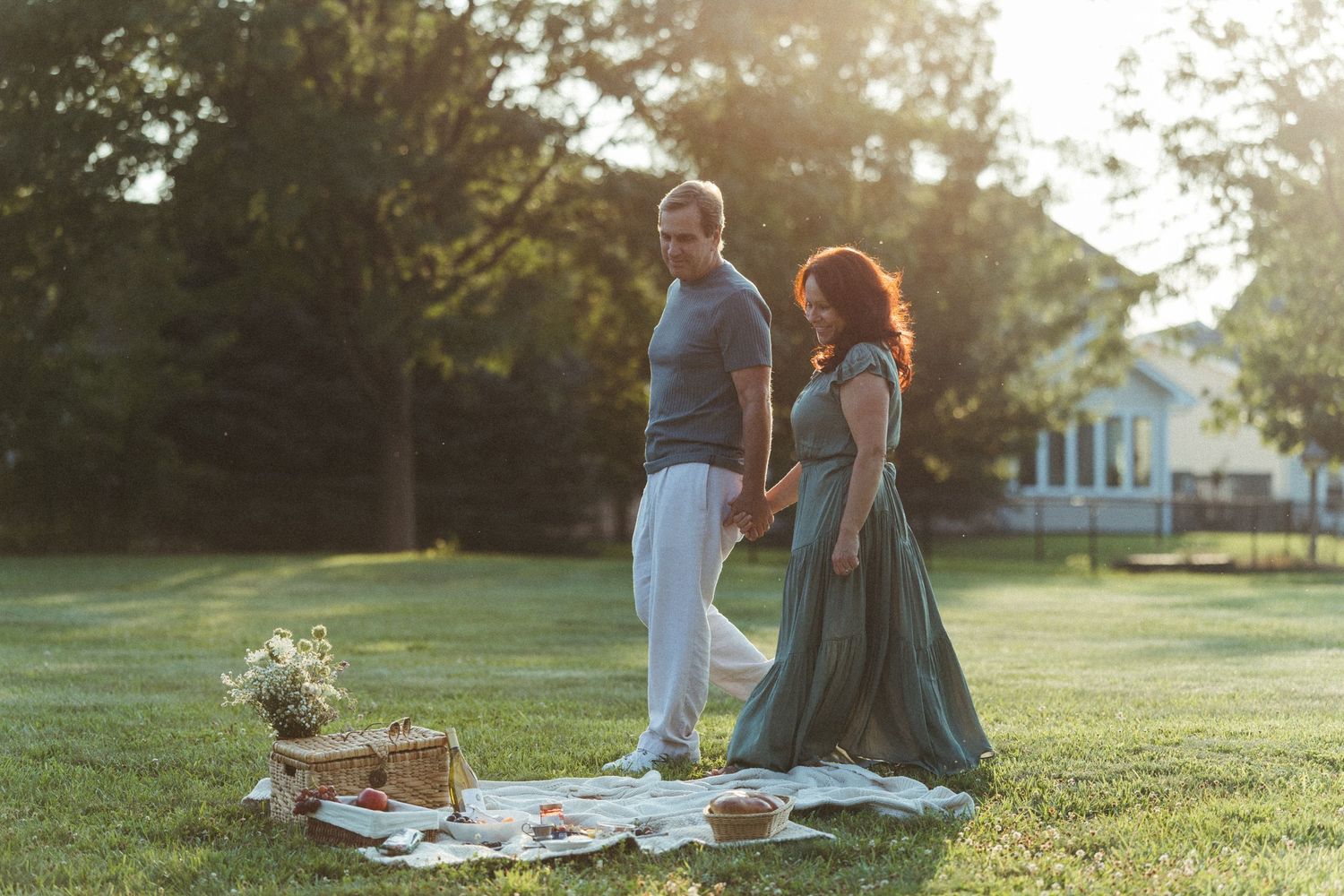 Romantic picnic scene with couple sharing intimate moment at sunset.