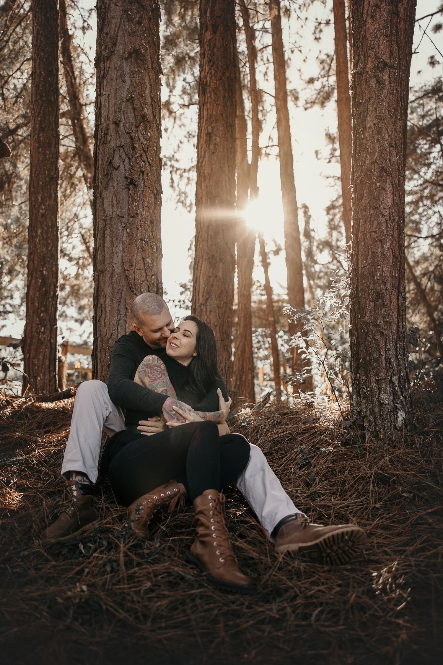Romantic forest photoshoot with sunlight streaming through tall pine trees.
