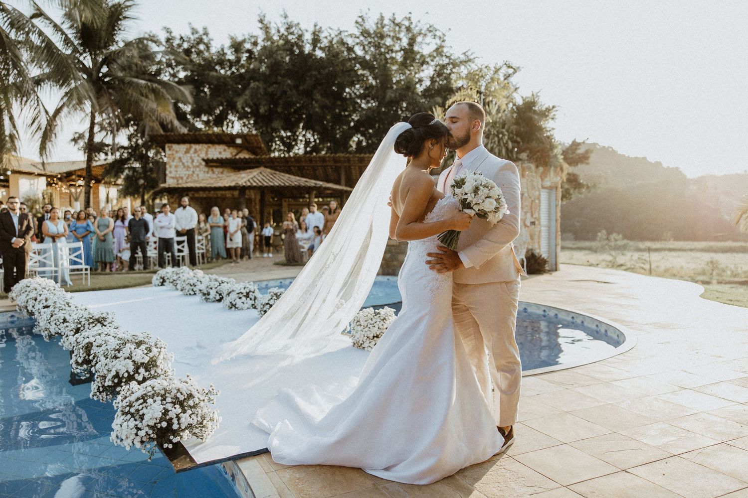 Romantic beachside wedding ceremony setup with palm trees at sunset.